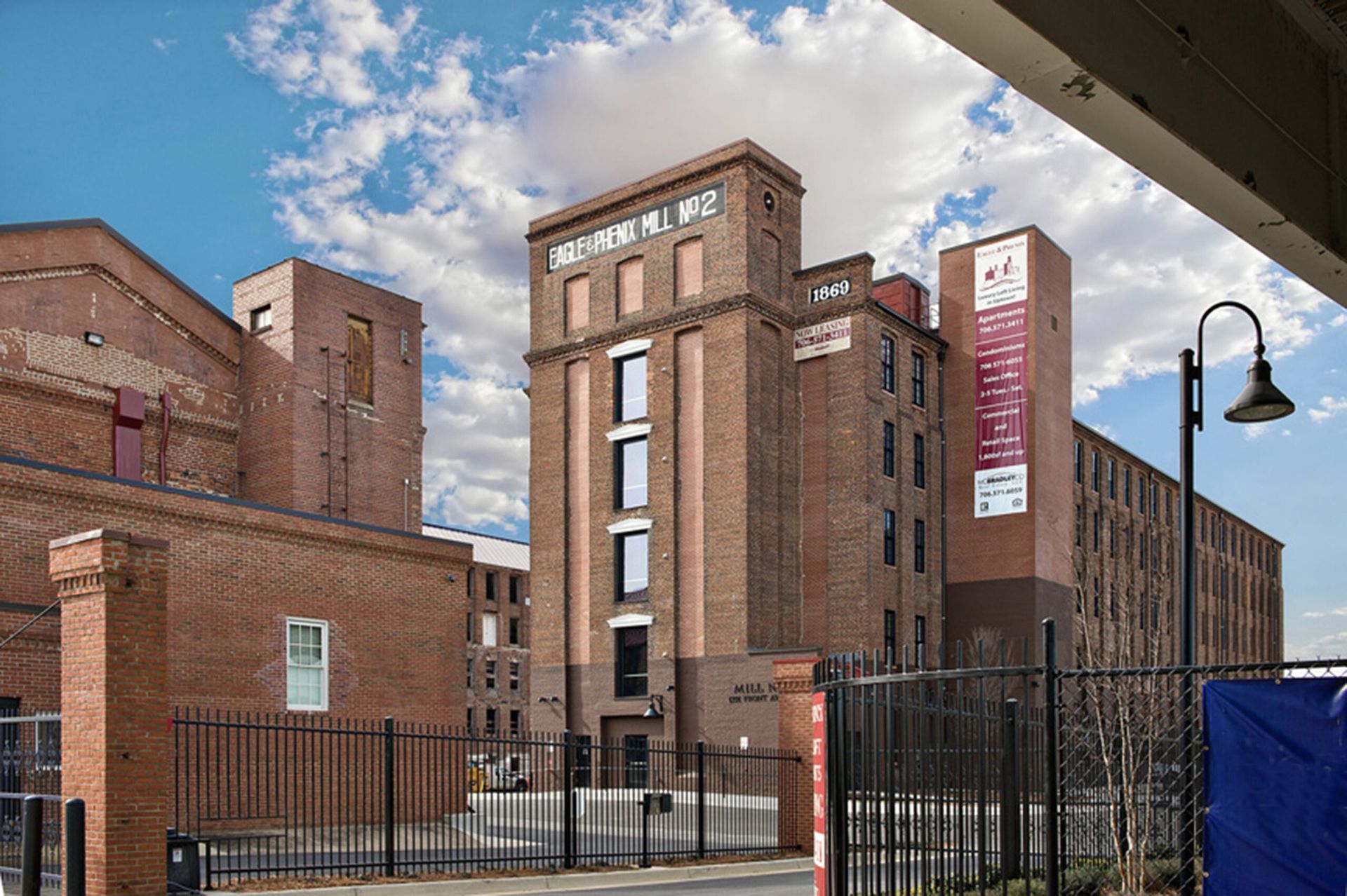 A large brick building with a fence in front of it.