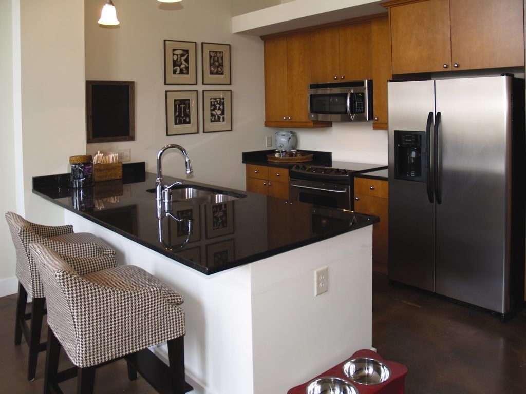 A kitchen with stainless steel appliances and a black counter top