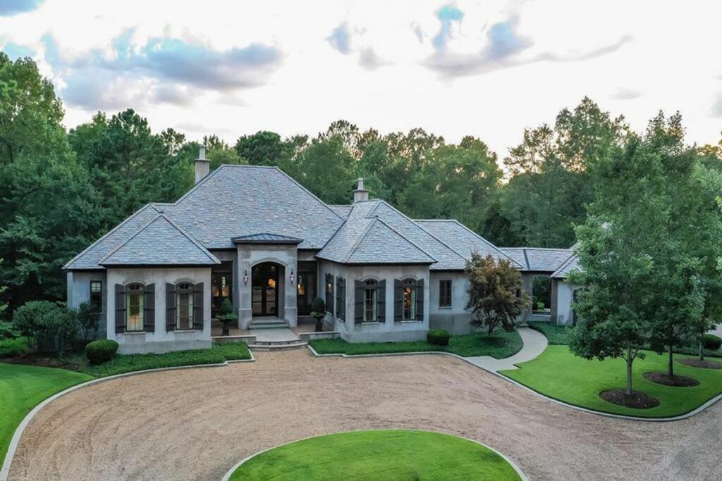 A large house with a gravel driveway in front of it