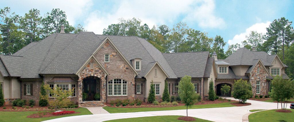 A large house with a gray roof is surrounded by trees