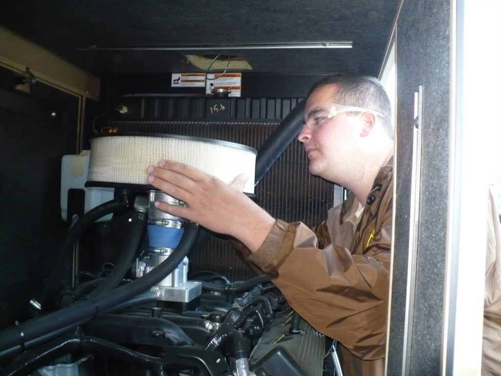 A man in a brown jacket is working on a machine