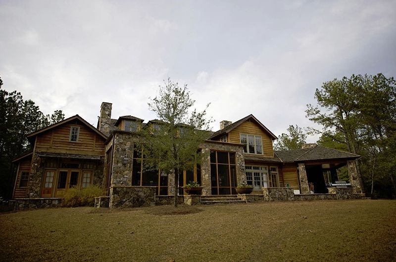 A large house with a lot of windows is surrounded by trees