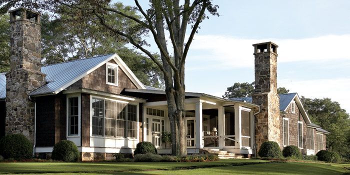 A large house with a porch and two chimneys