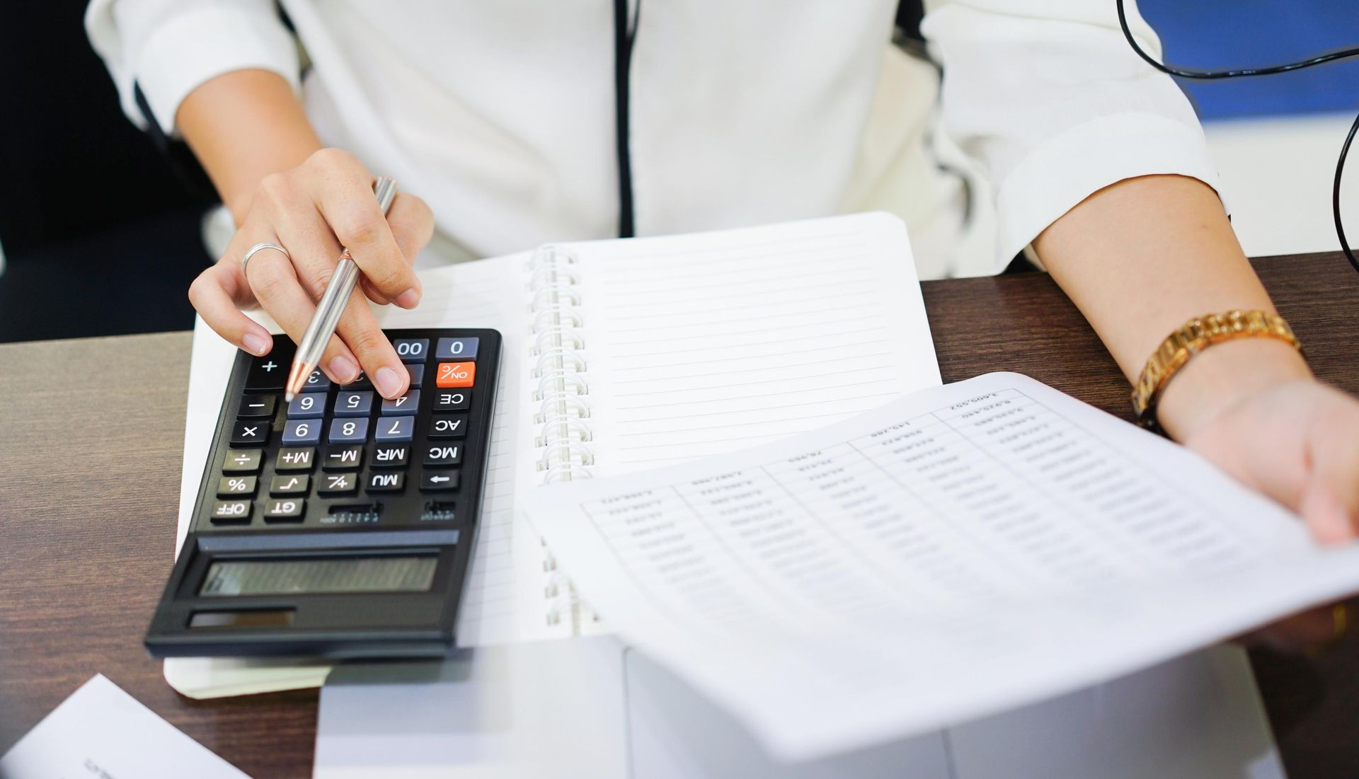 Calculator, pen, and 1040 tax form on a wooden desk.