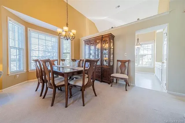 A dining room with a table and chairs and a chandelier.