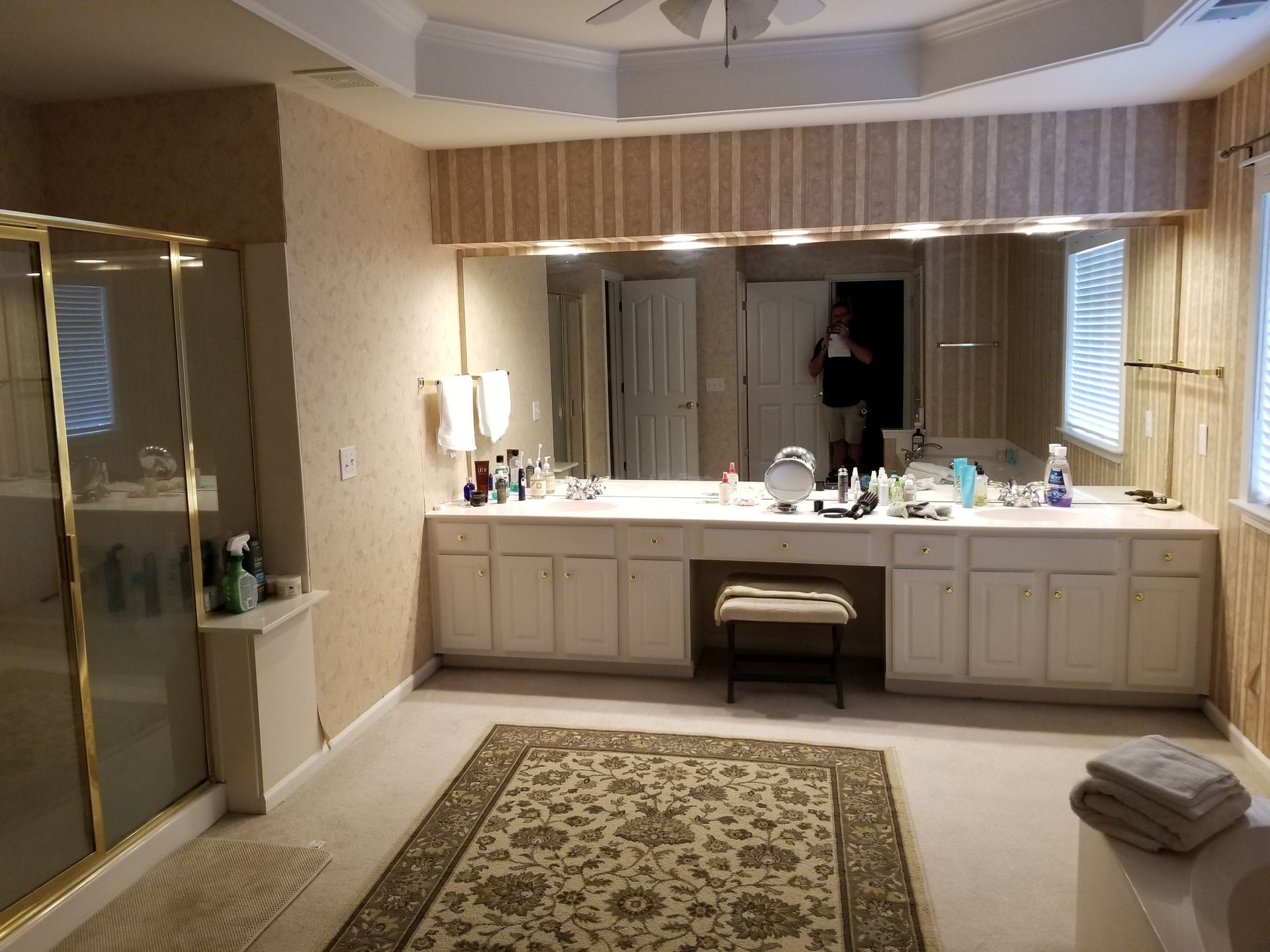 A bathroom with a large mirror and a rug.