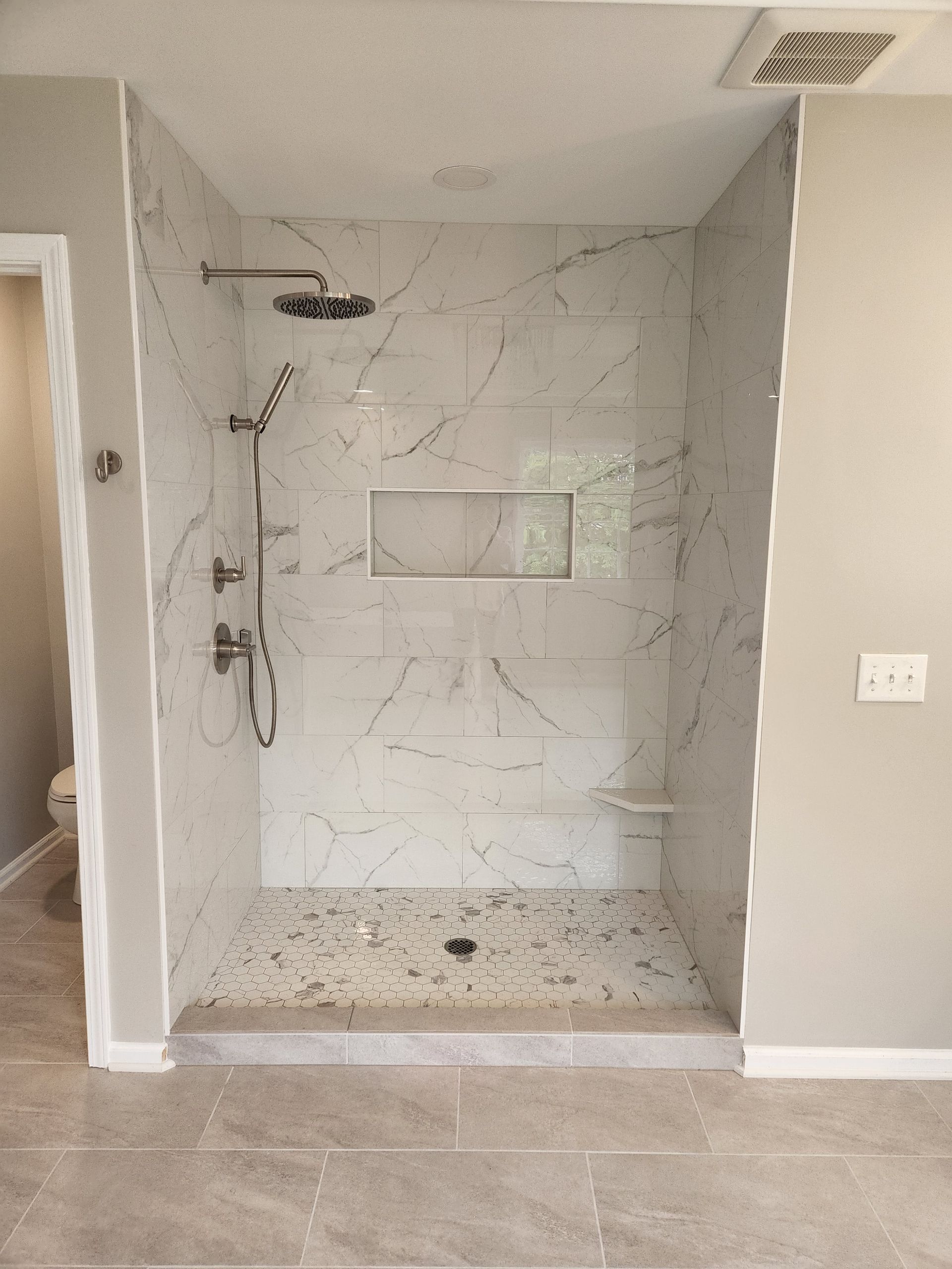 A bathroom with a walk in shower and a toilet.