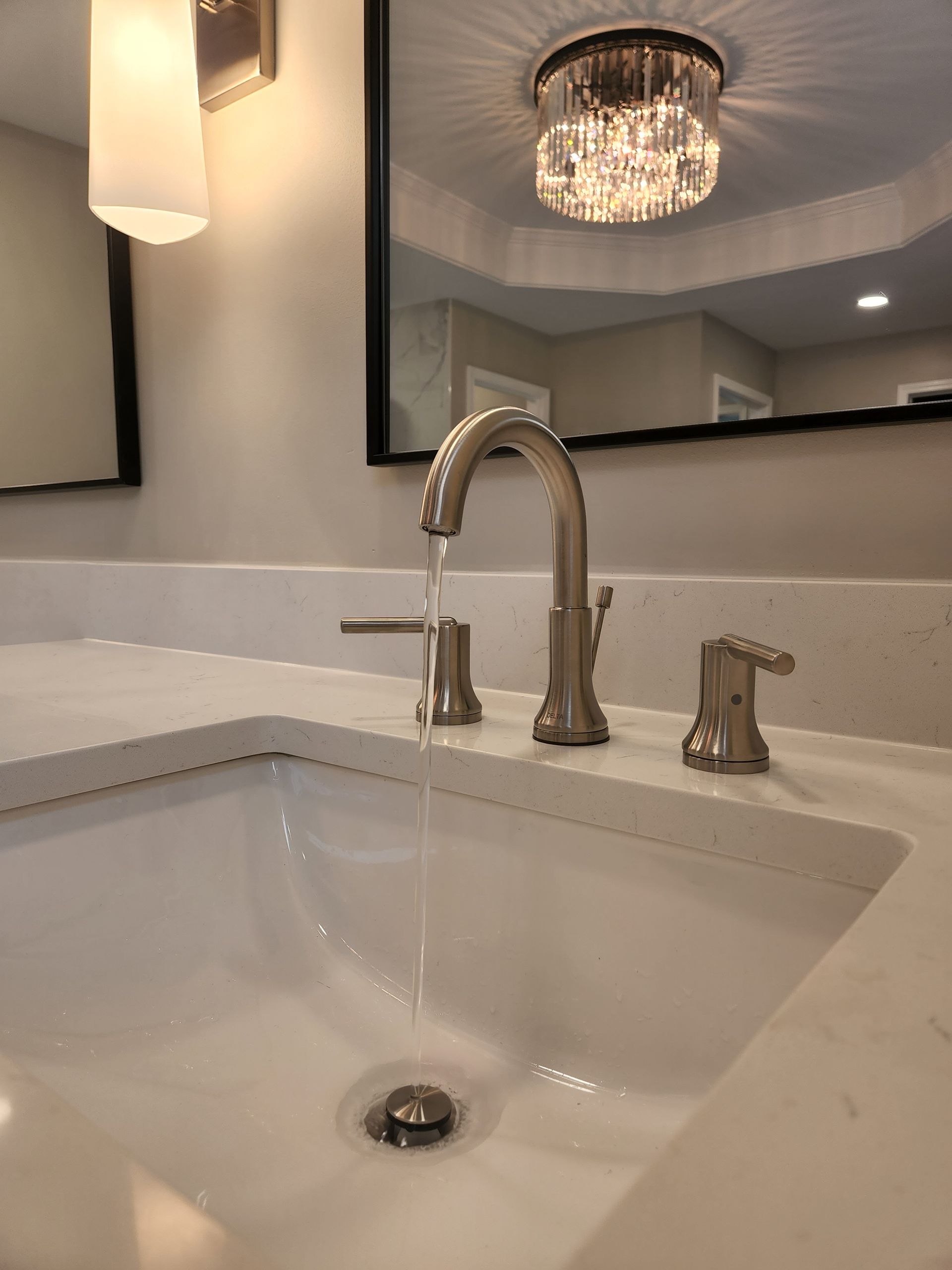 A bathroom sink with a faucet and a mirror.