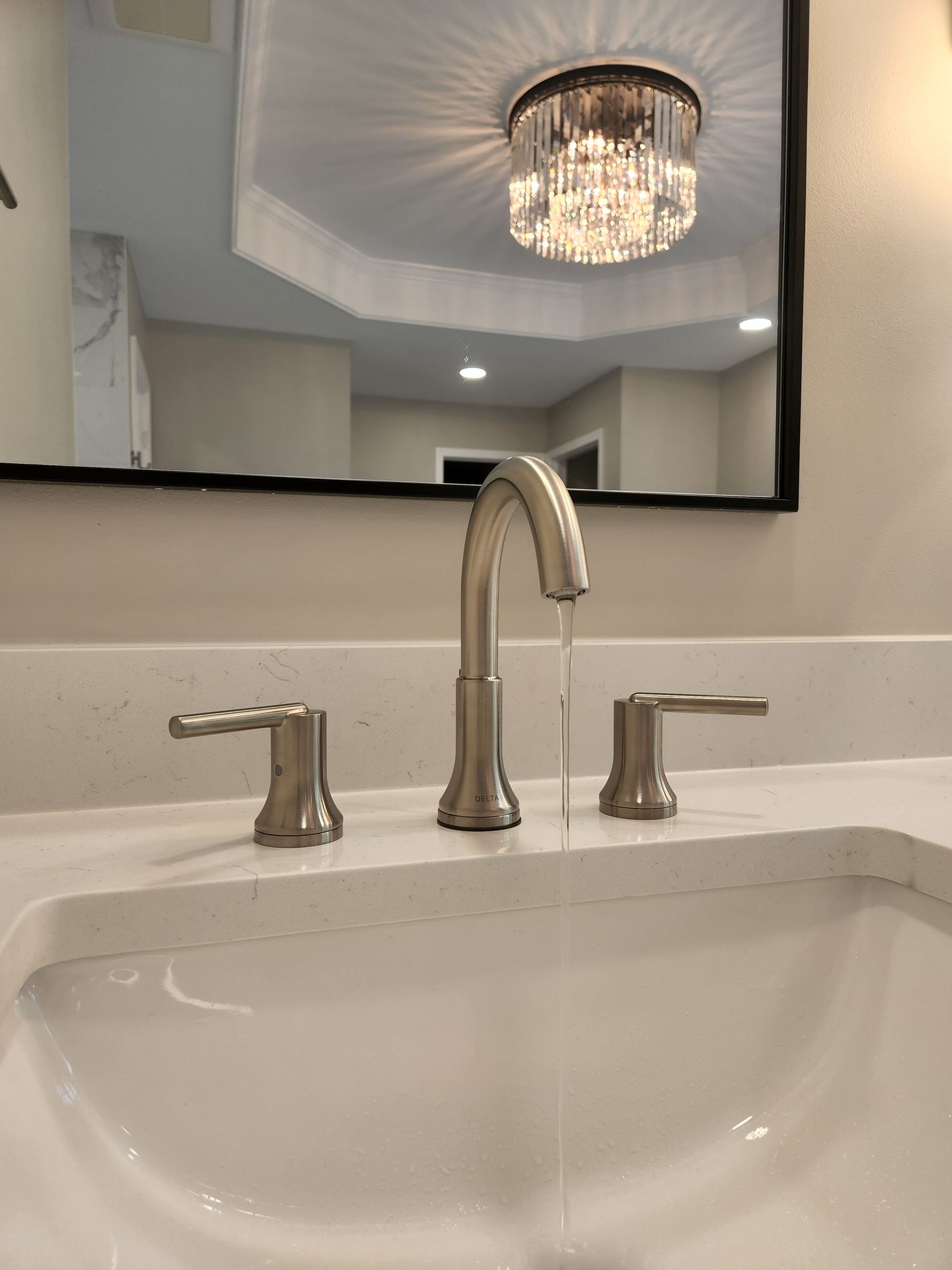 A bathroom sink with a faucet and a mirror.