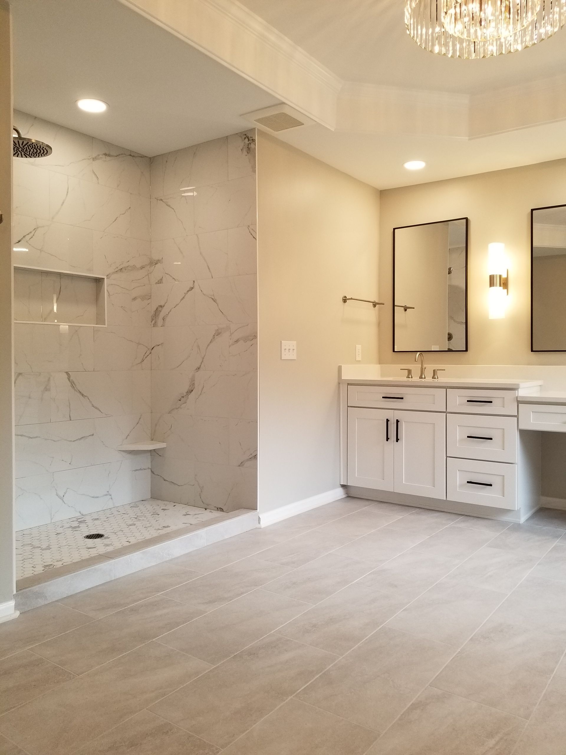 A bathroom with a walk in shower and a sink