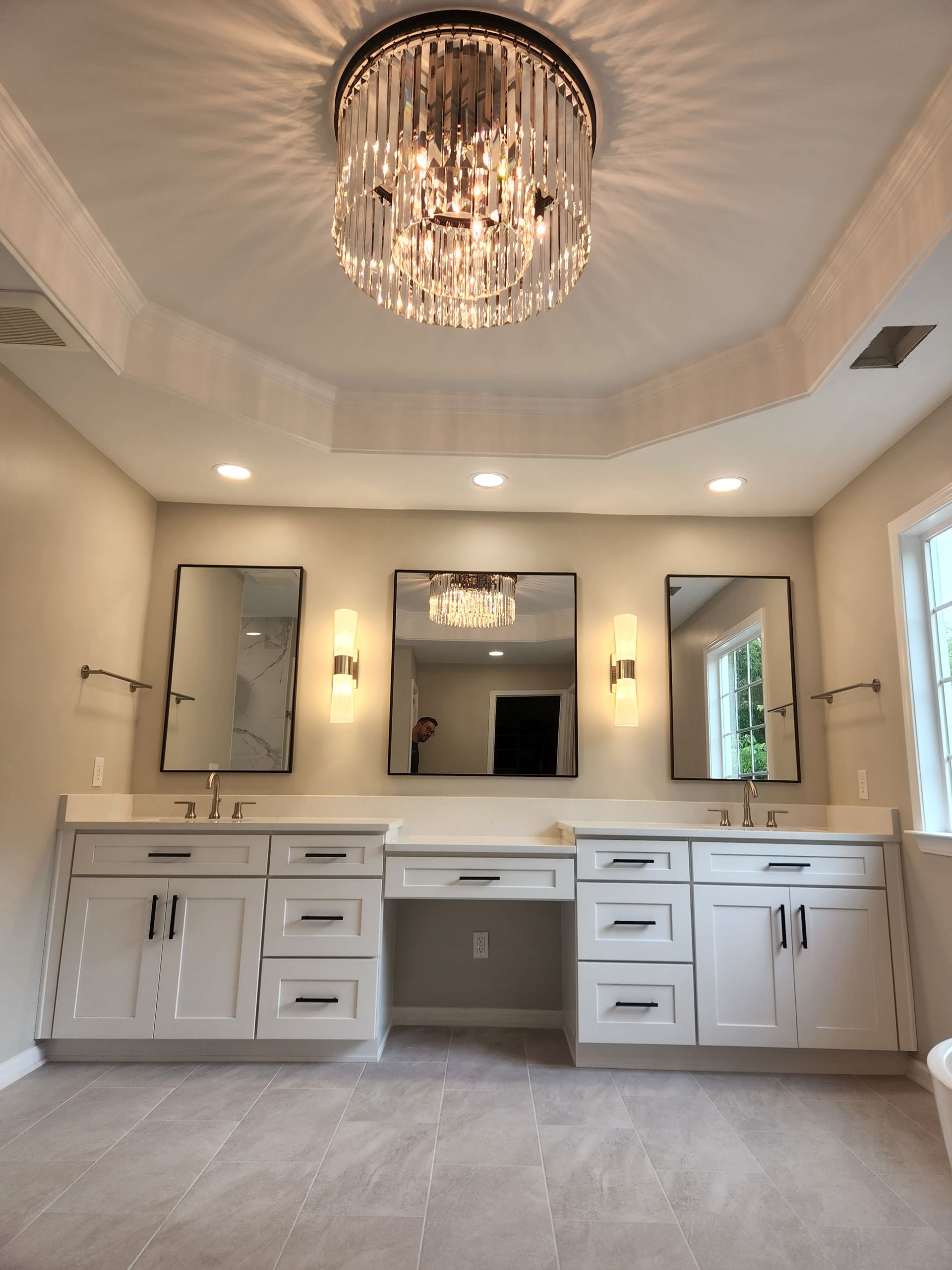 A bathroom with two sinks and a chandelier hanging from the ceiling