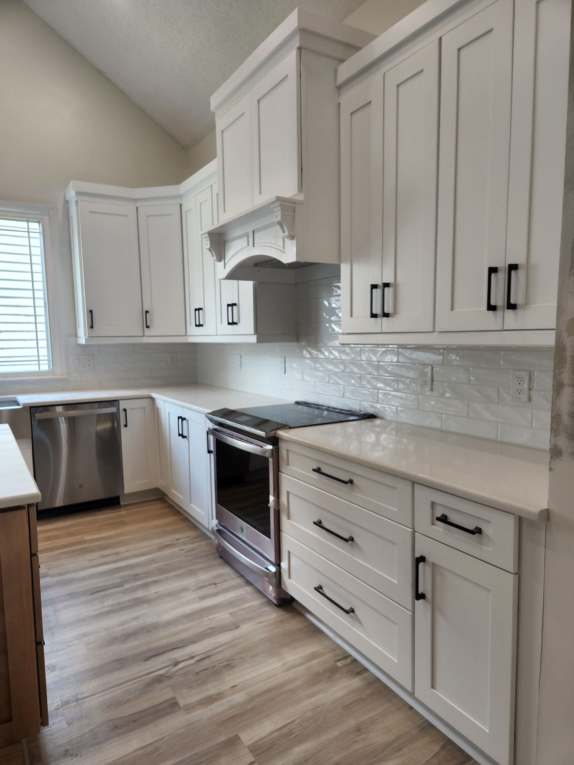 A kitchen with white cabinets and stainless steel appliances