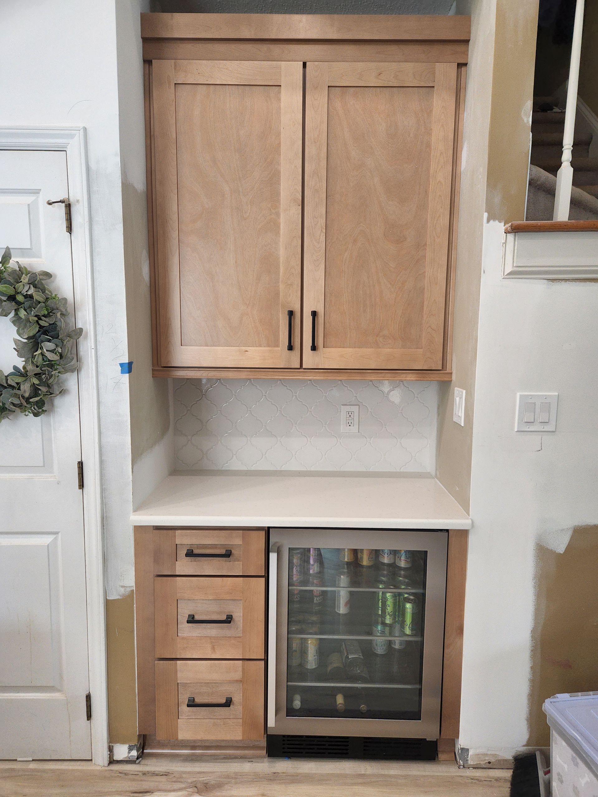 A kitchen with wooden cabinets and a stainless steel refrigerator