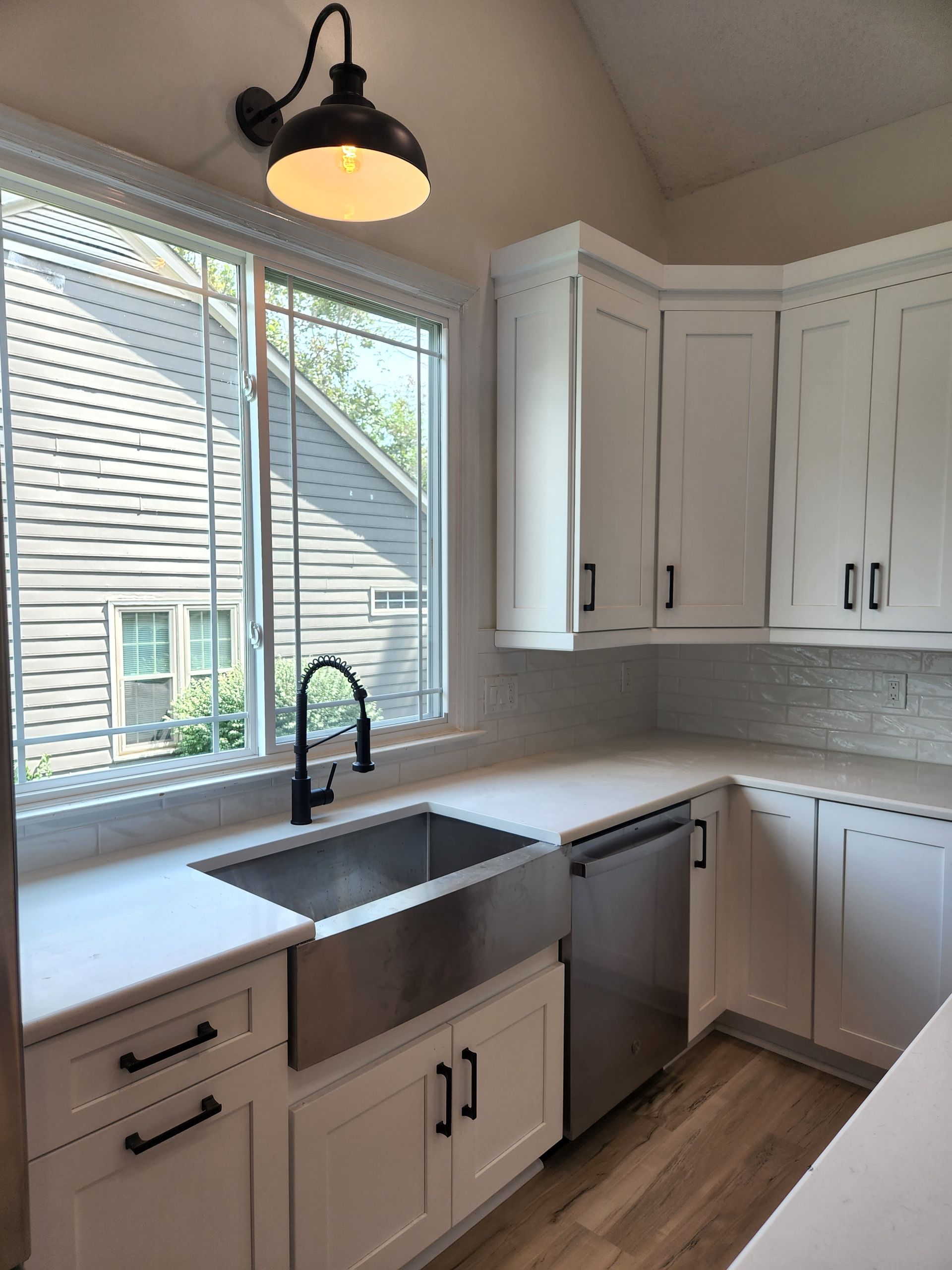 A kitchen with white cabinets and a stainless steel sink