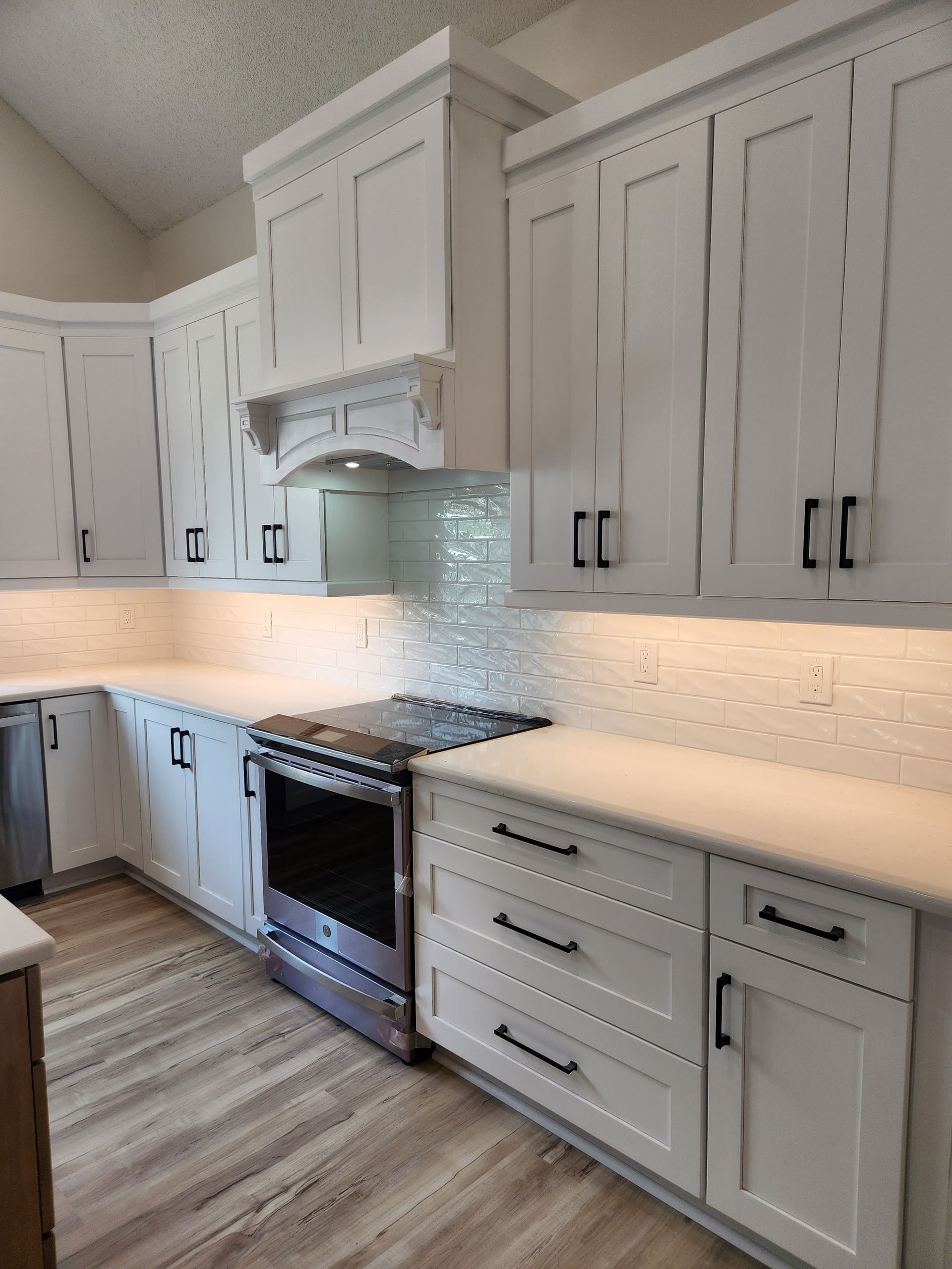 A kitchen with white cabinets and stainless steel appliances.