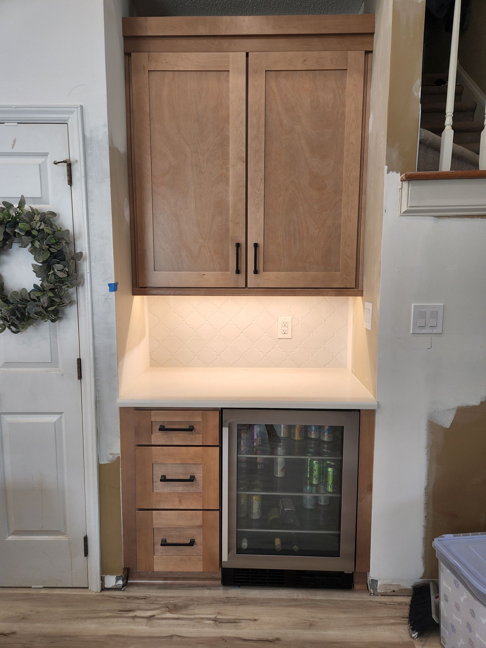 A kitchen with wooden cabinets and a stainless steel refrigerator