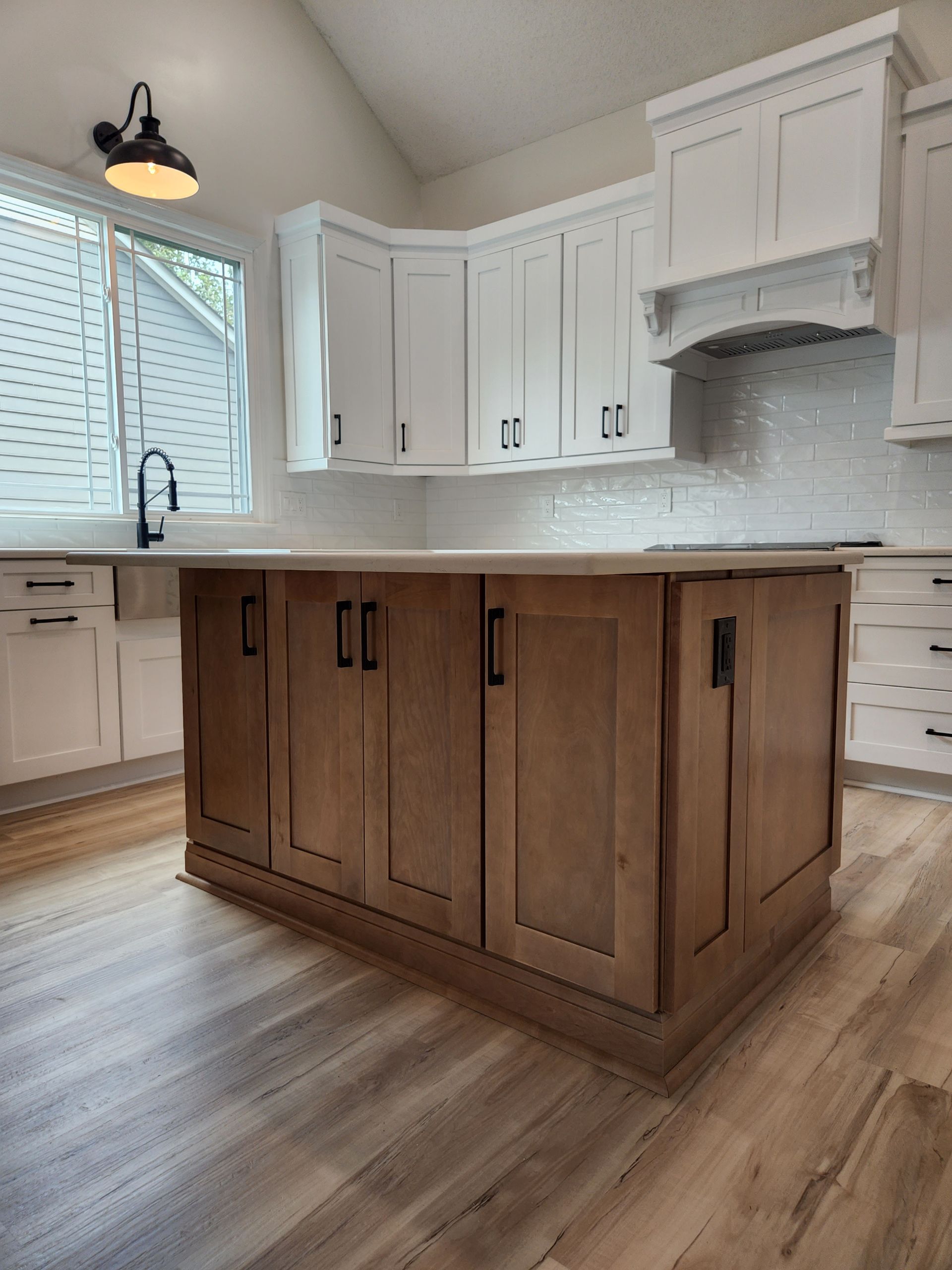 A kitchen with white cabinets and a large island in the middle