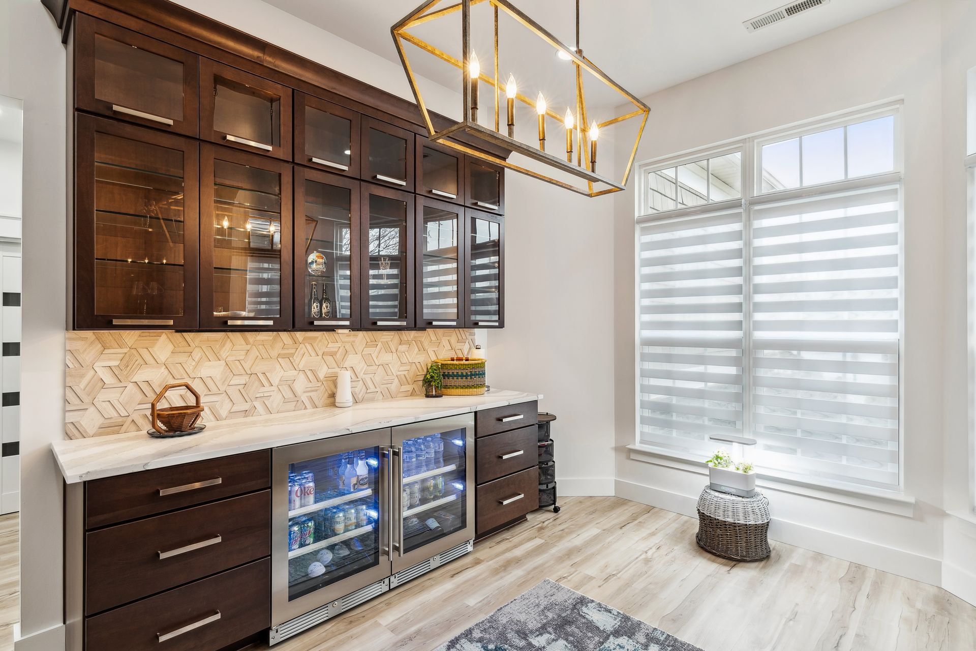 A kitchen with wooden cabinets, stainless steel appliances, a refrigerator and a chandelier.
