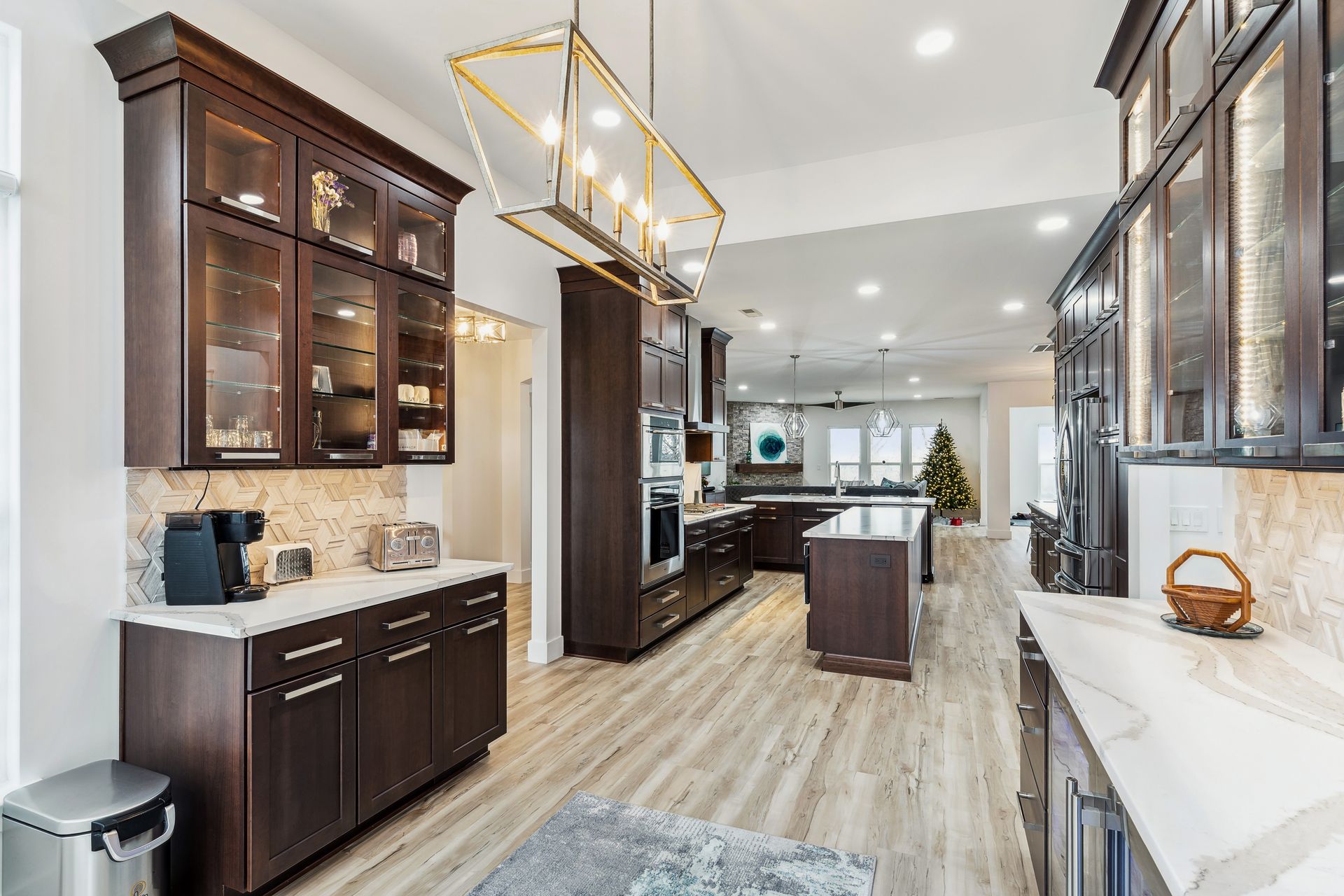 A kitchen with a lot of cabinets and a chandelier hanging from the ceiling.