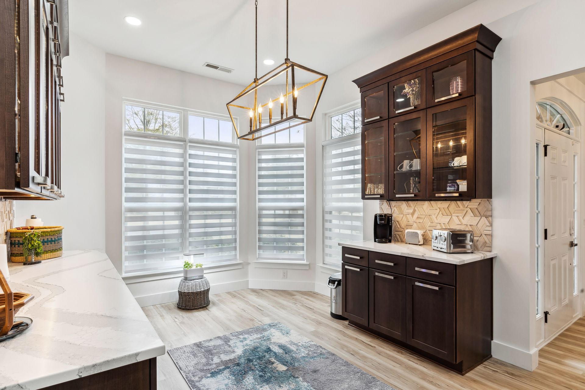 A kitchen with wooden cabinets and a chandelier hanging from the ceiling.