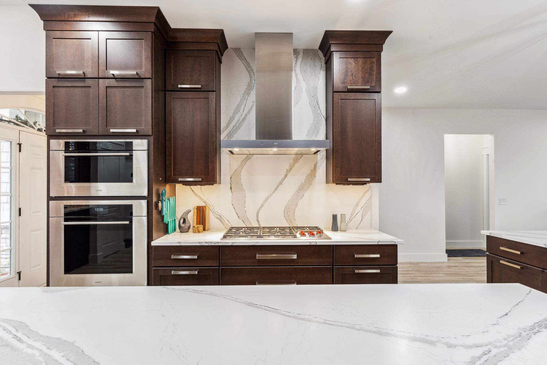 A kitchen with wooden cabinets, stainless steel appliances, and a white counter top.
