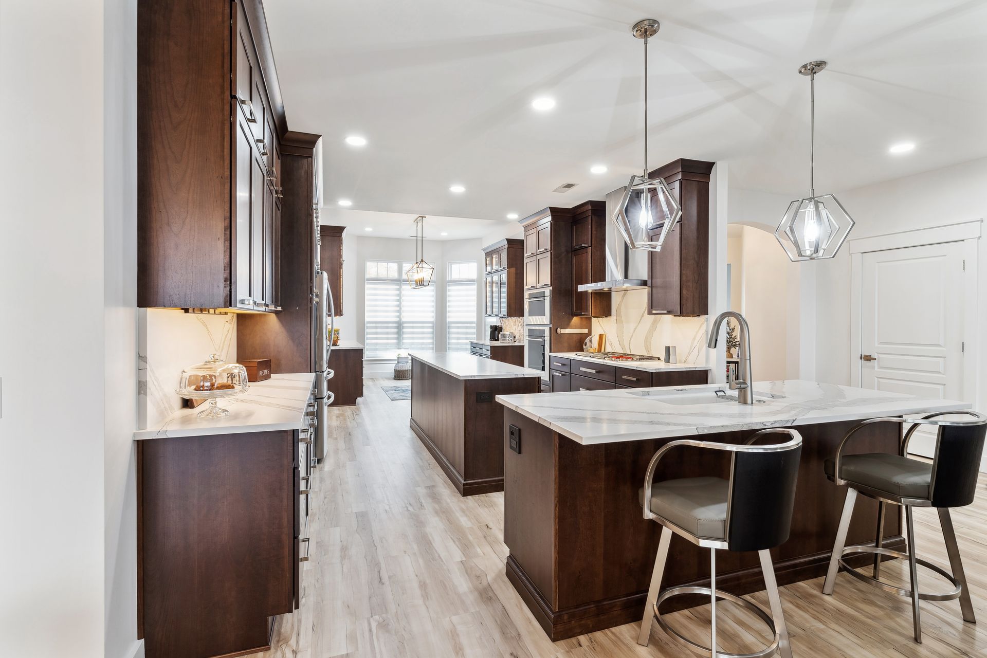 A kitchen with a large island and marble counter tops.