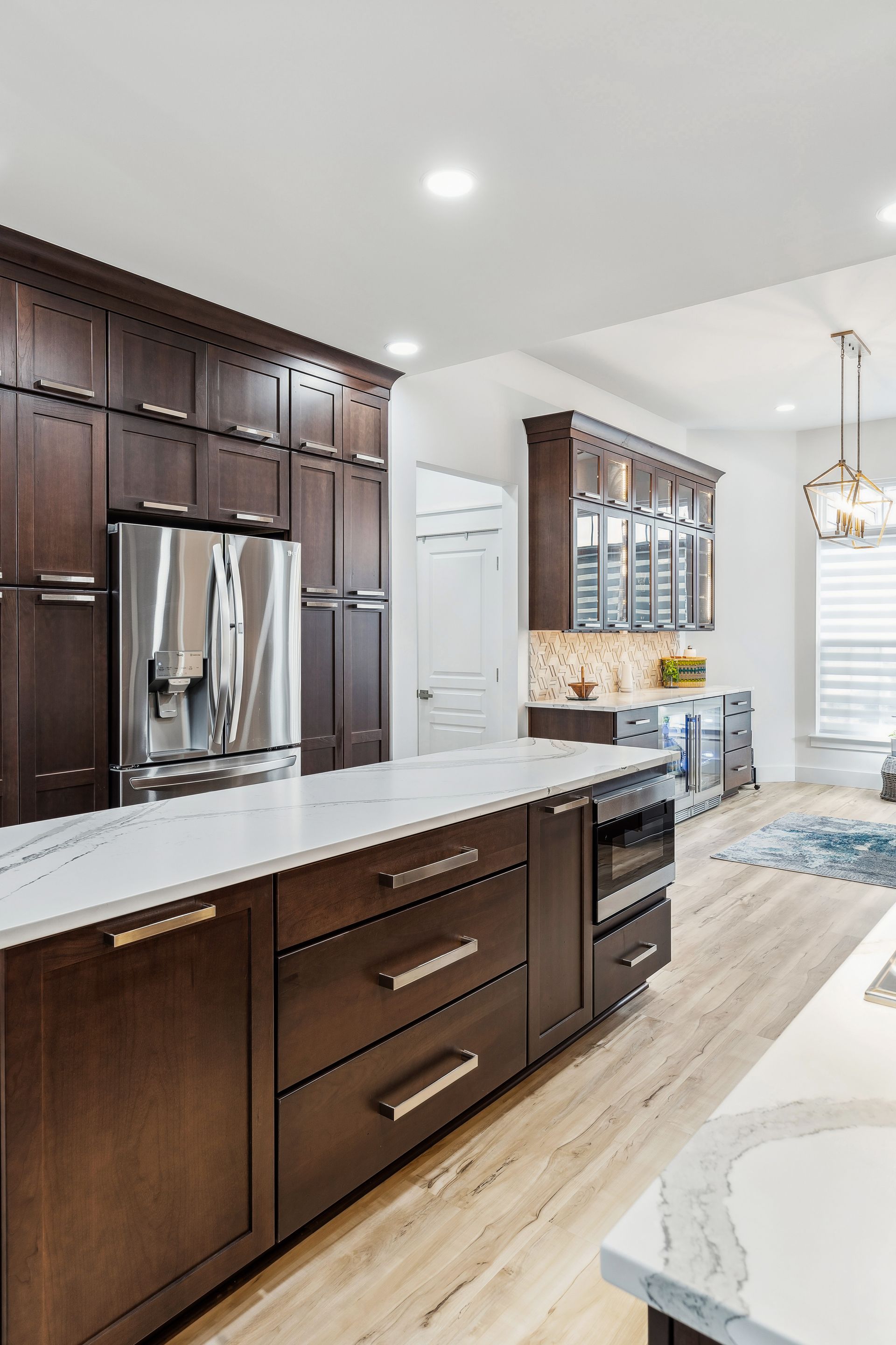 A kitchen with wooden cabinets, stainless steel appliances, and a large island.
