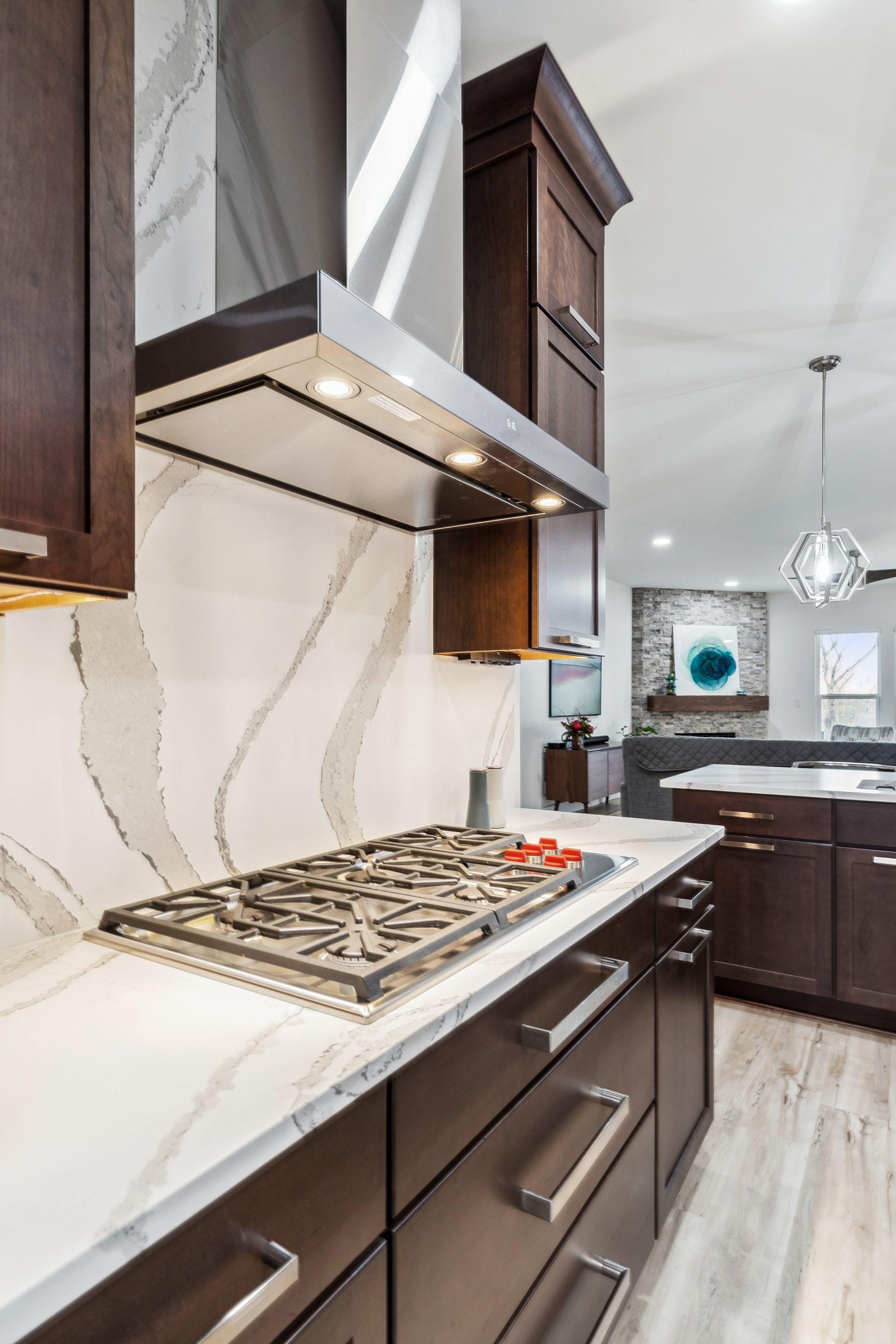 A kitchen with a stove top oven and a hood above it.