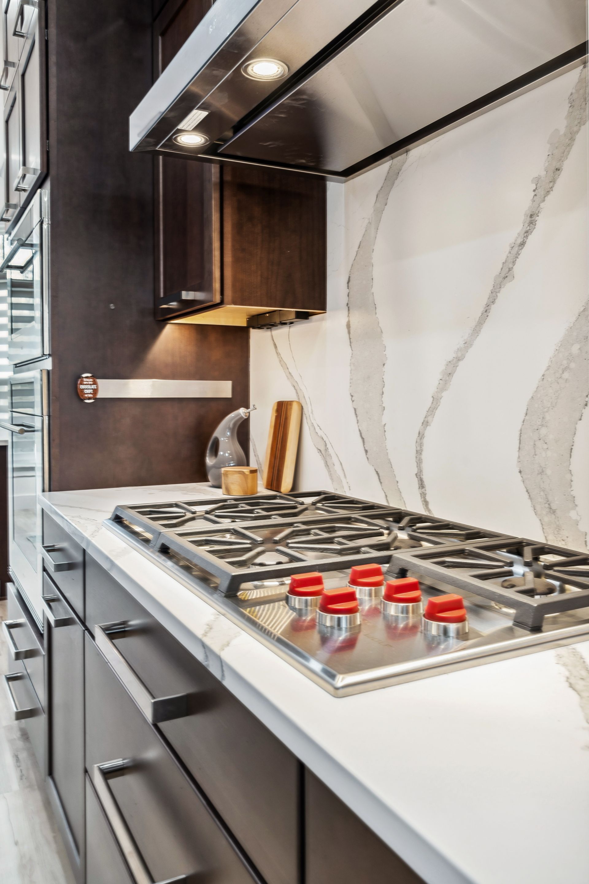 A kitchen with a stove top oven and a hood.