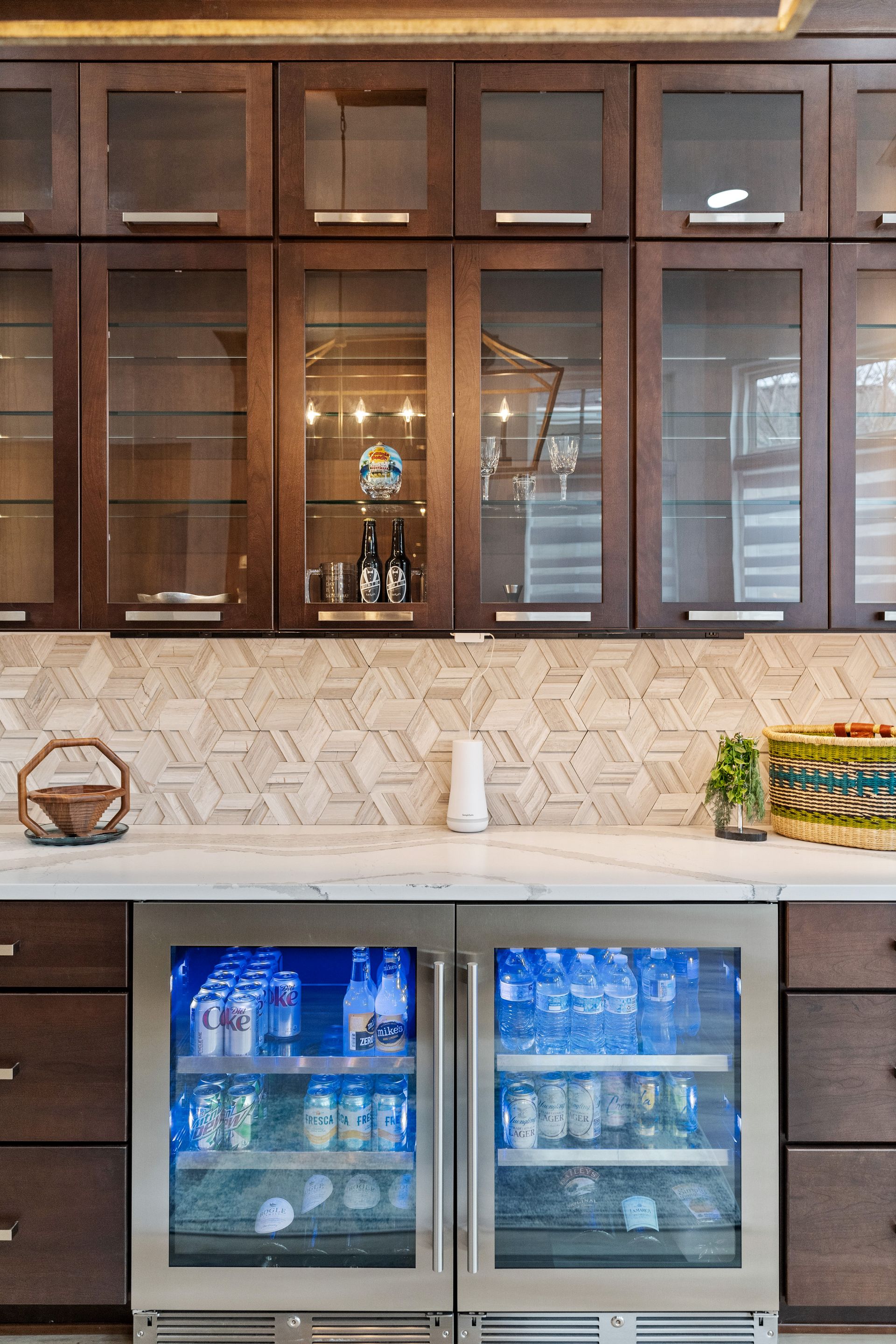 A kitchen with stainless steel cabinets and a glass door refrigerator.
