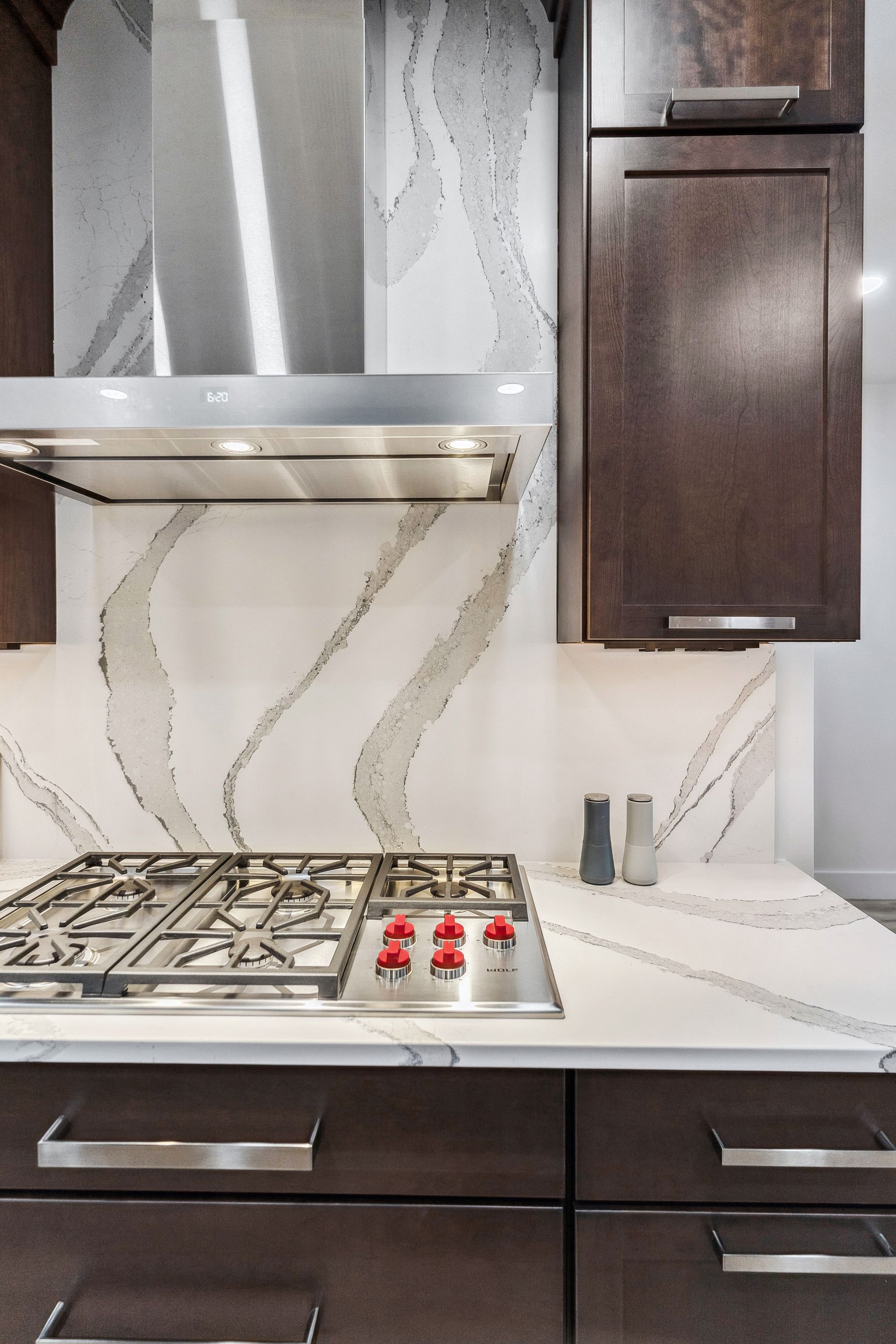 A kitchen with a stove top oven and a hood above it.