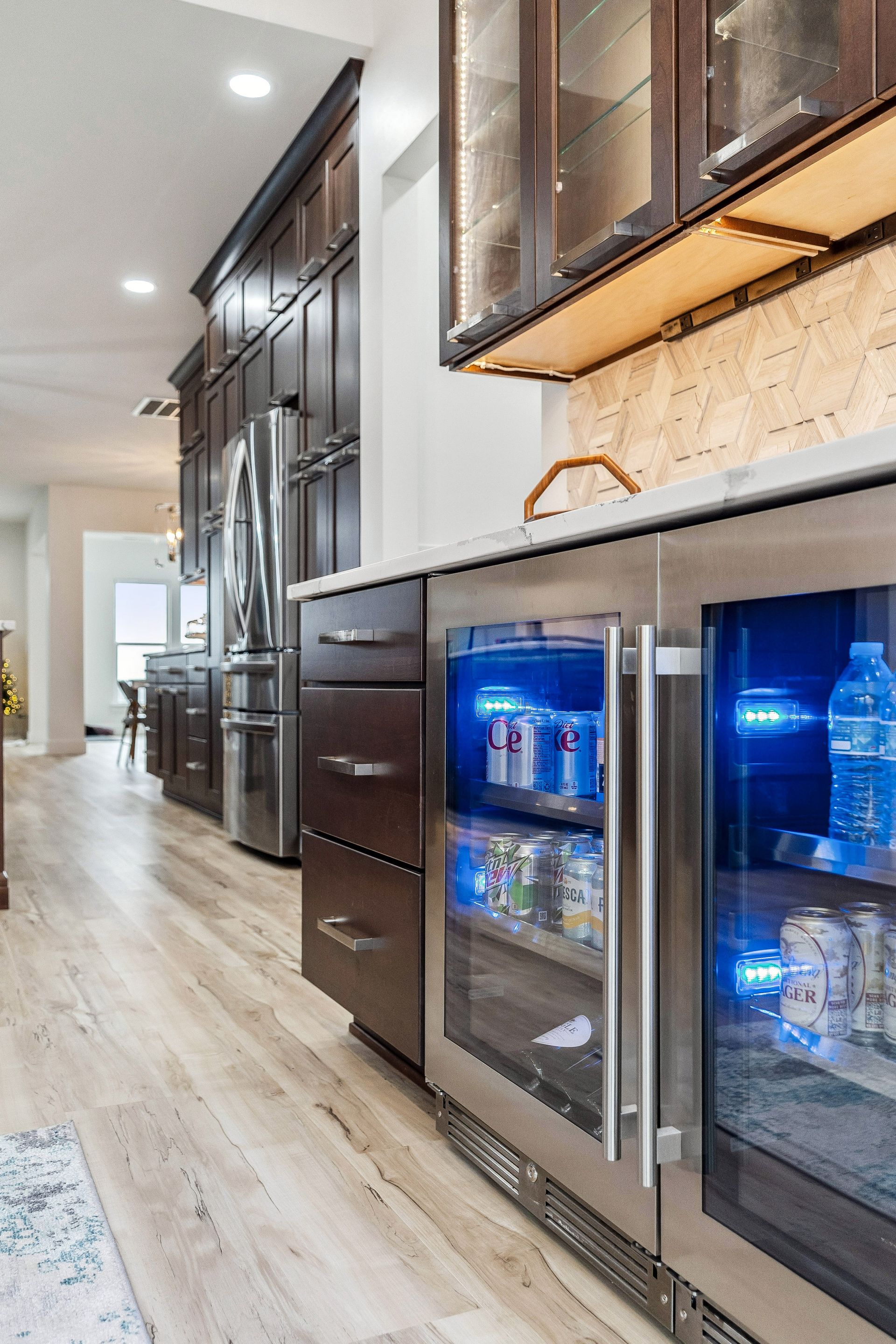 A kitchen with stainless steel cabinets and a refrigerator with a glass door.