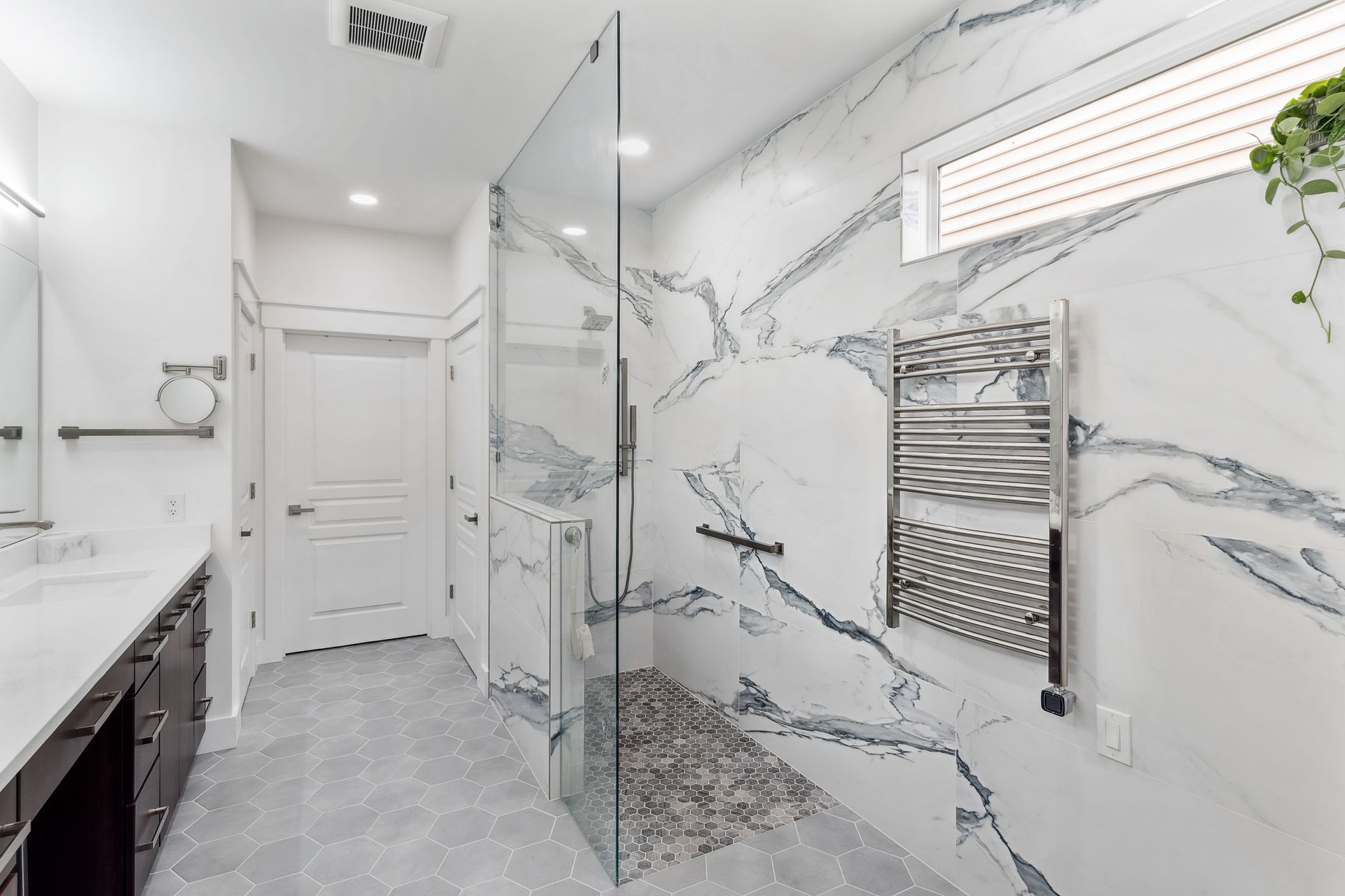 A bathroom with marble walls and a walk in shower.