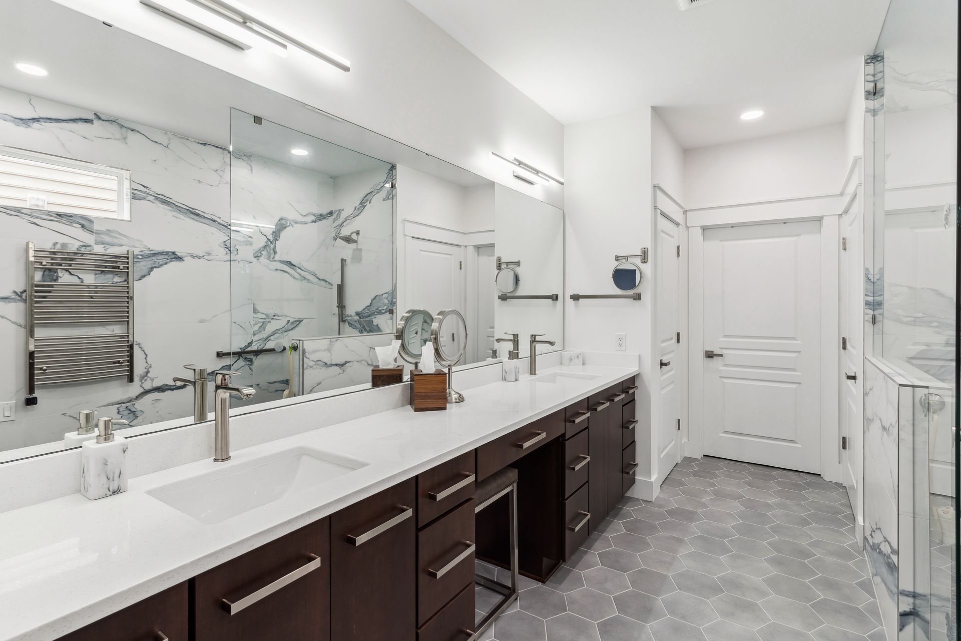 A bathroom with two sinks and a large mirror.