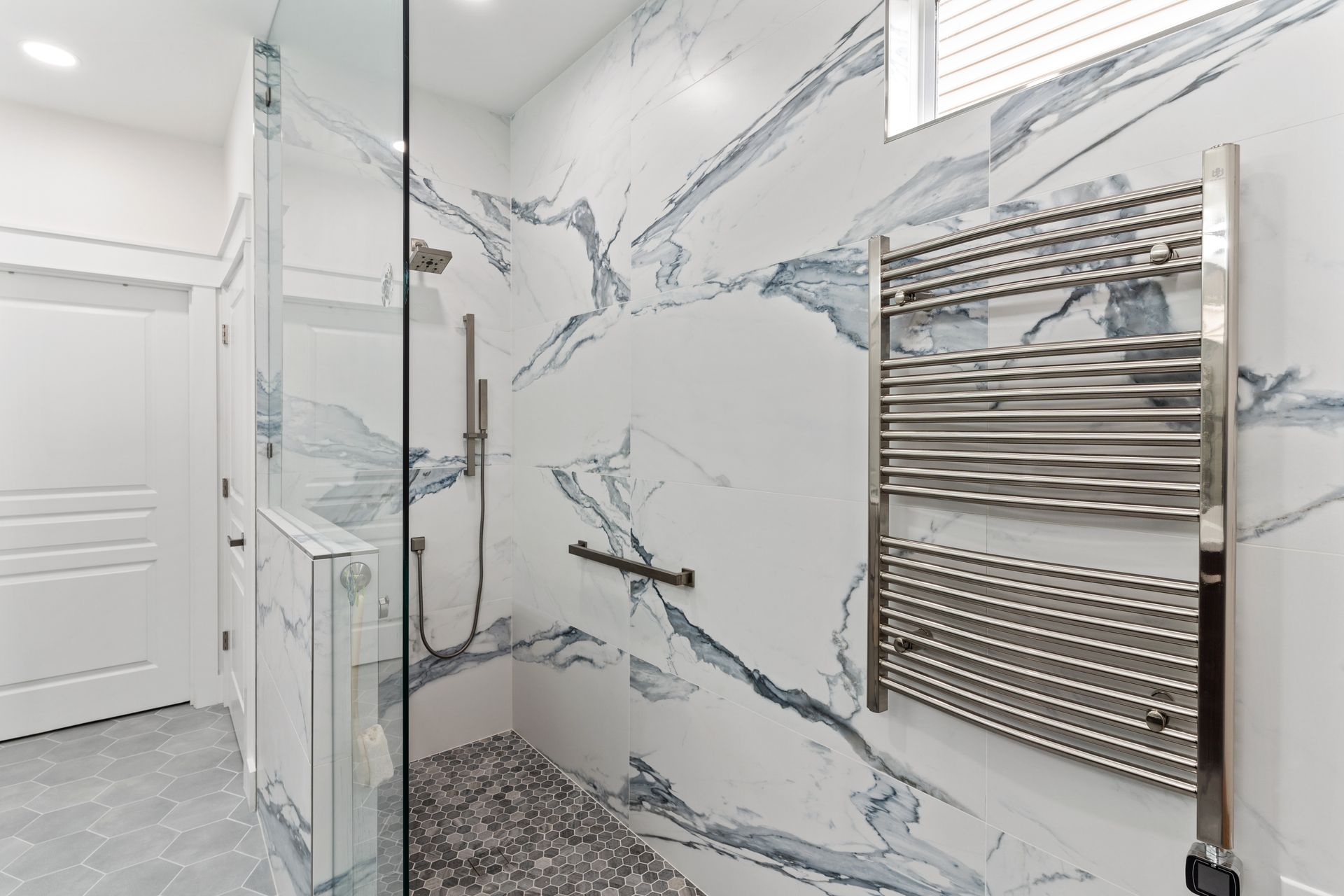A bathroom with a walk in shower and a towel rack.