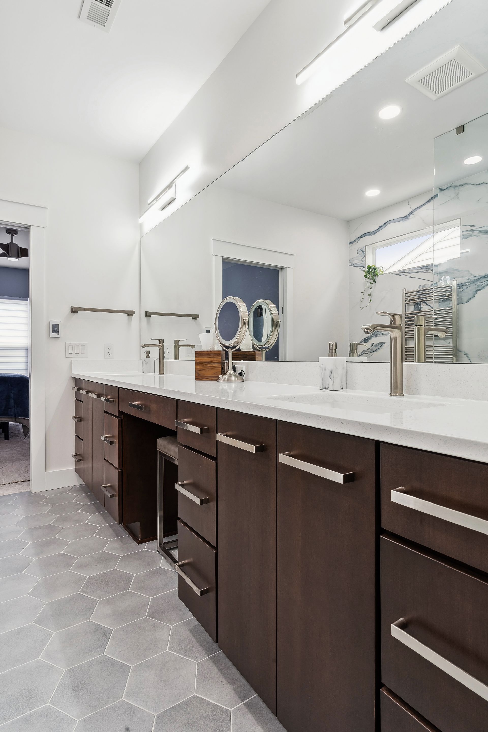 A bathroom with two sinks and a large mirror.