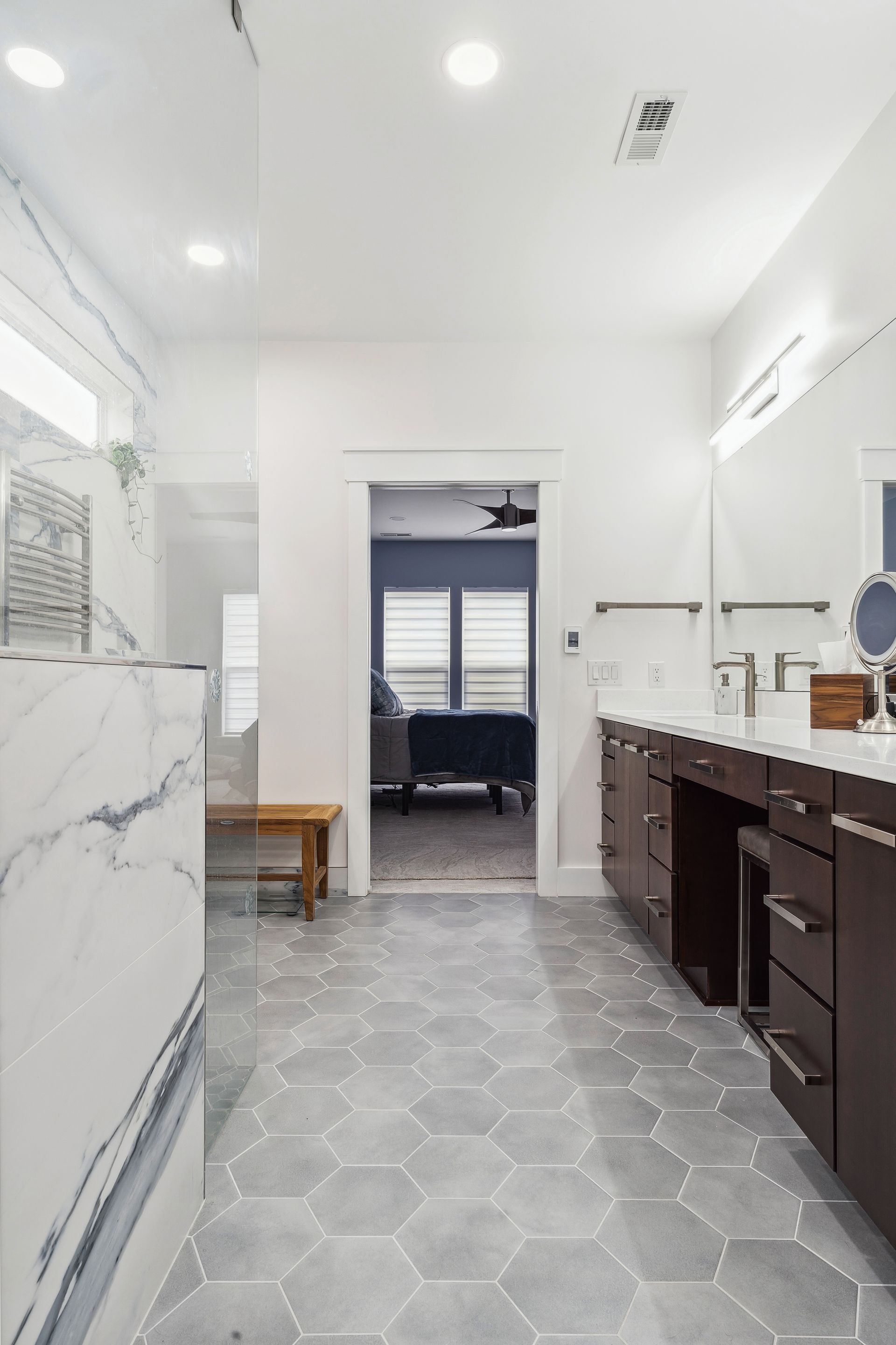 A bathroom with two sinks and a walk in shower.