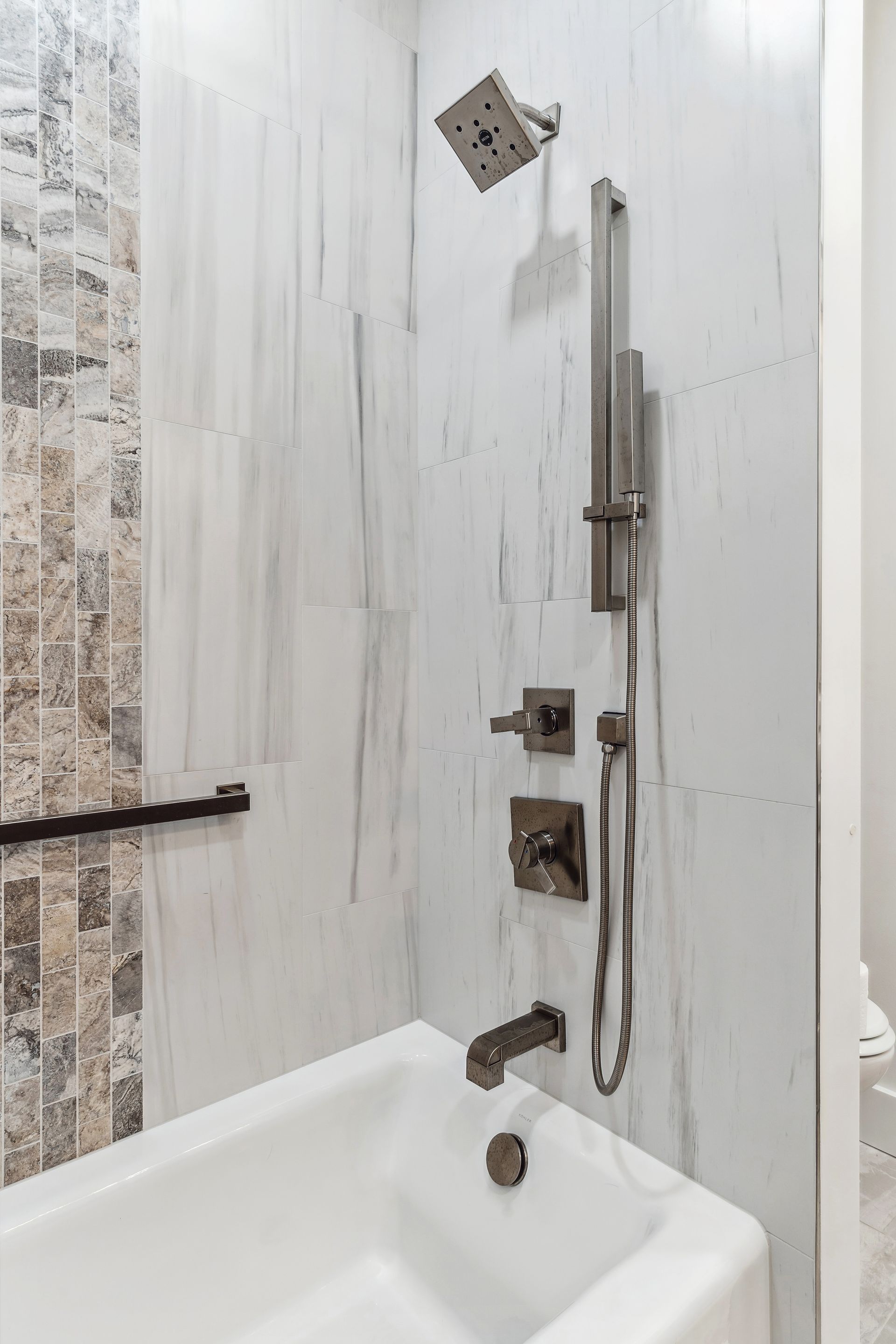 A bathroom with a bathtub and a shower.