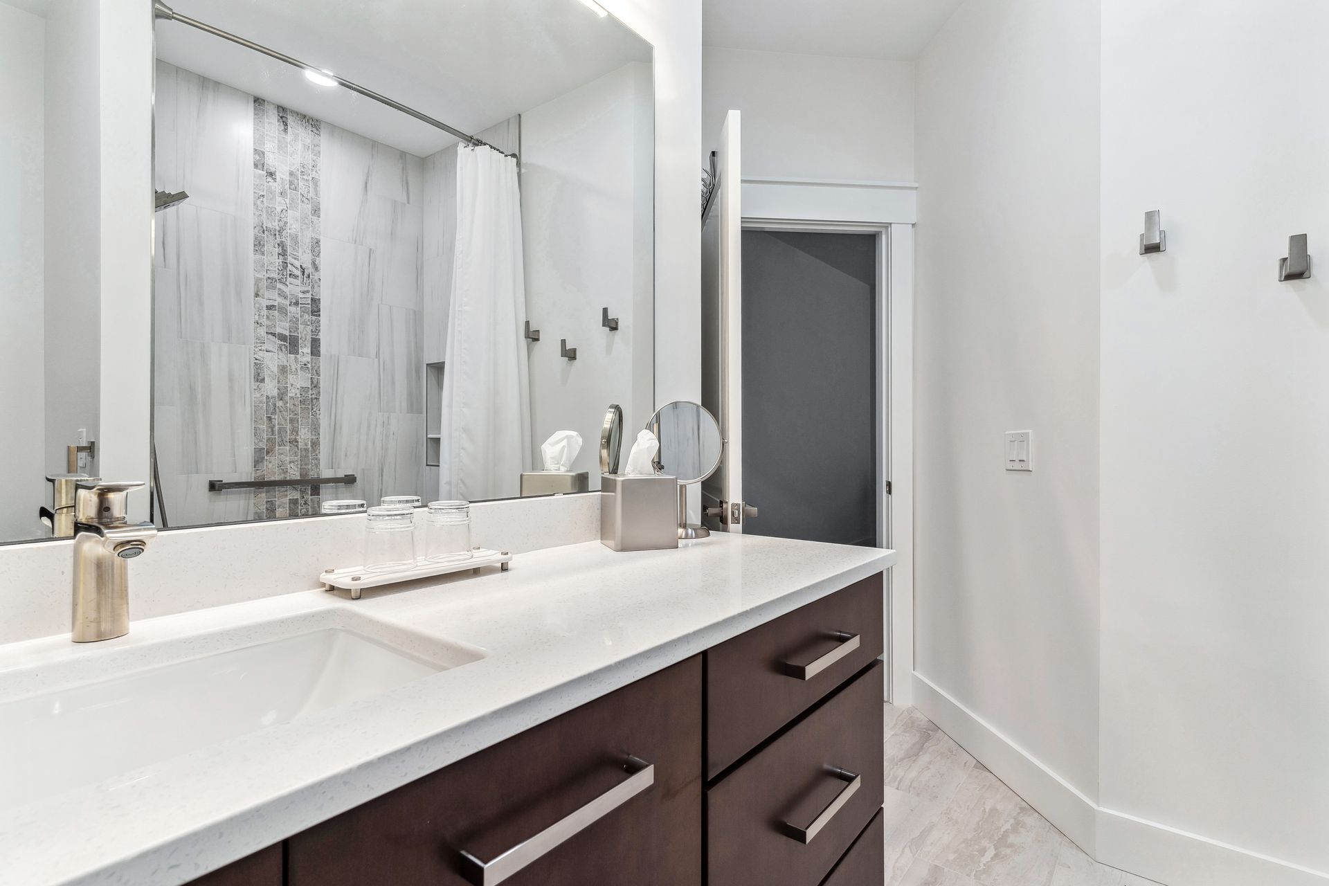 A bathroom with a double sink and a large mirror.