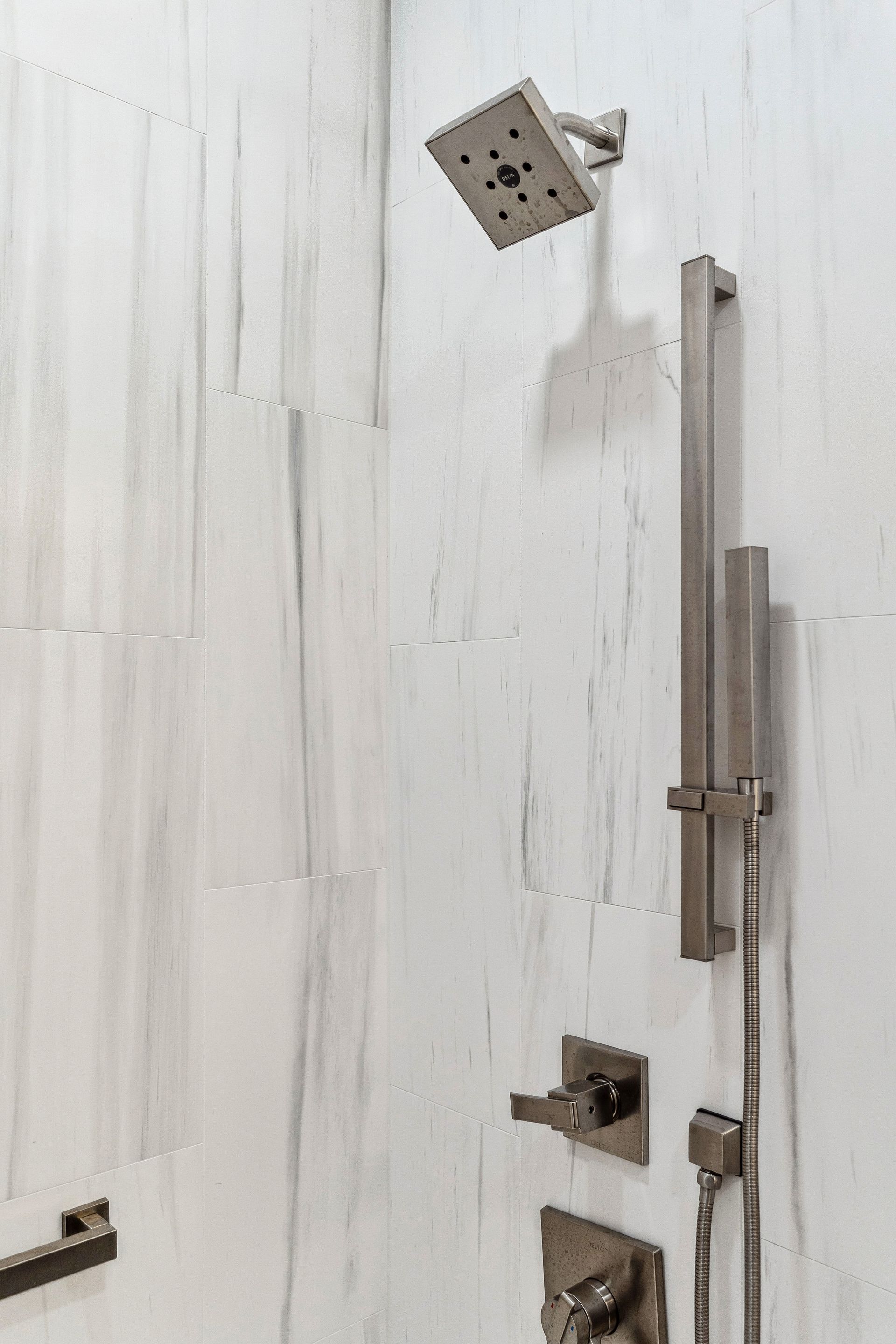 A close up of a shower head in a bathroom.