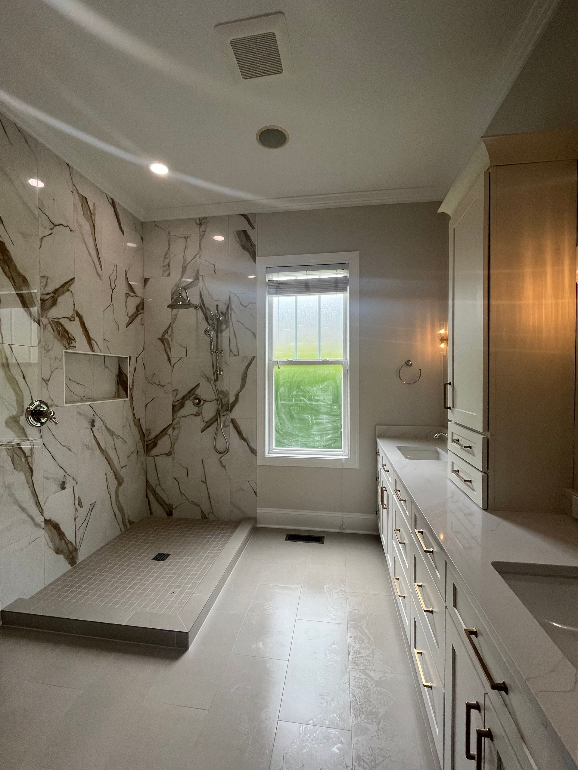 A bathroom with a walk in shower and a window