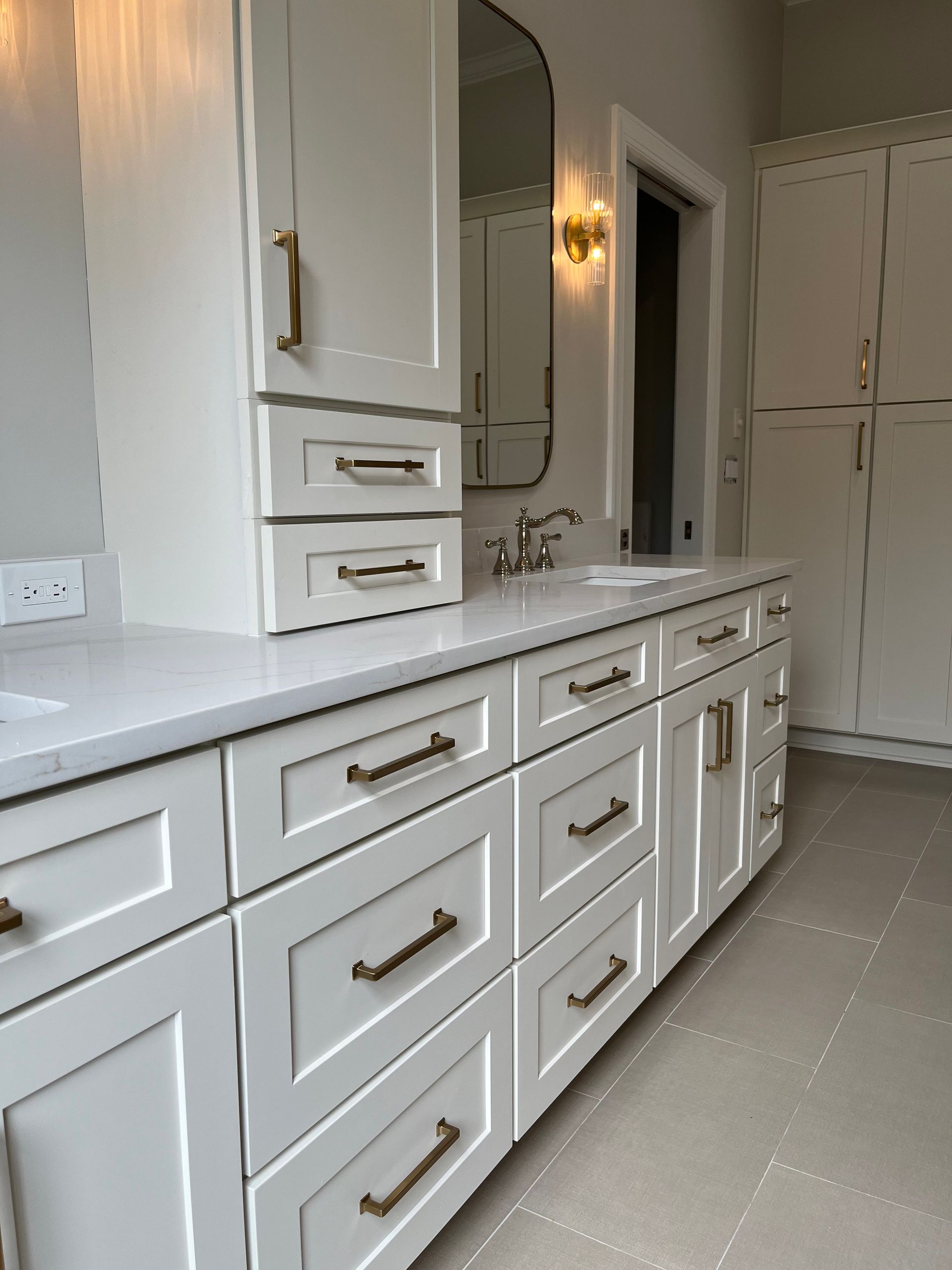 A bathroom with lots of white cabinets and drawers