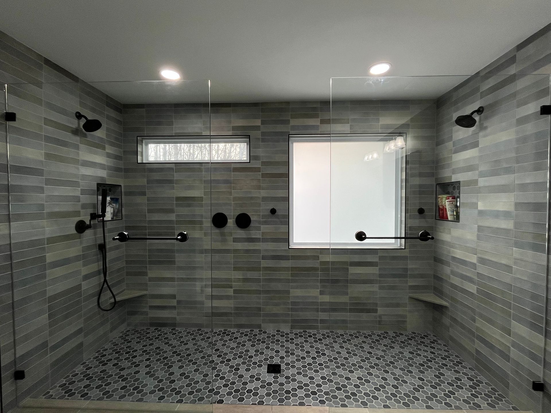 A bathroom with a walk in shower and a window.