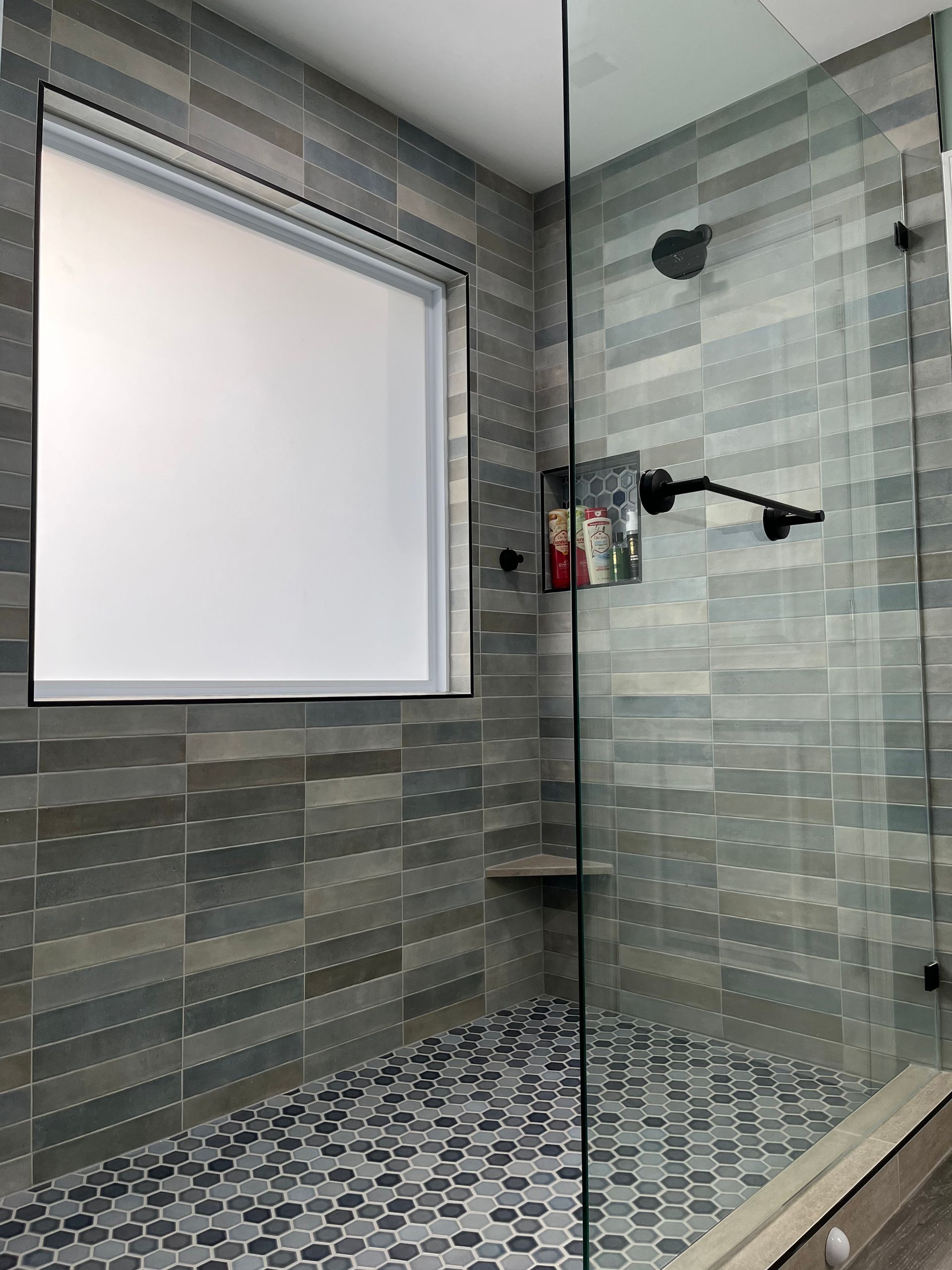 A bathroom with a walk in shower and a window