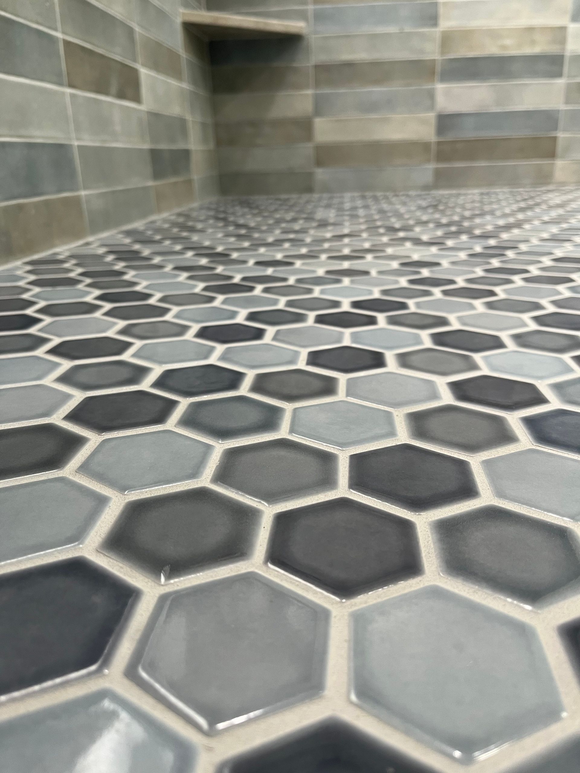 A close up of a bathroom floor with hexagonal tiles