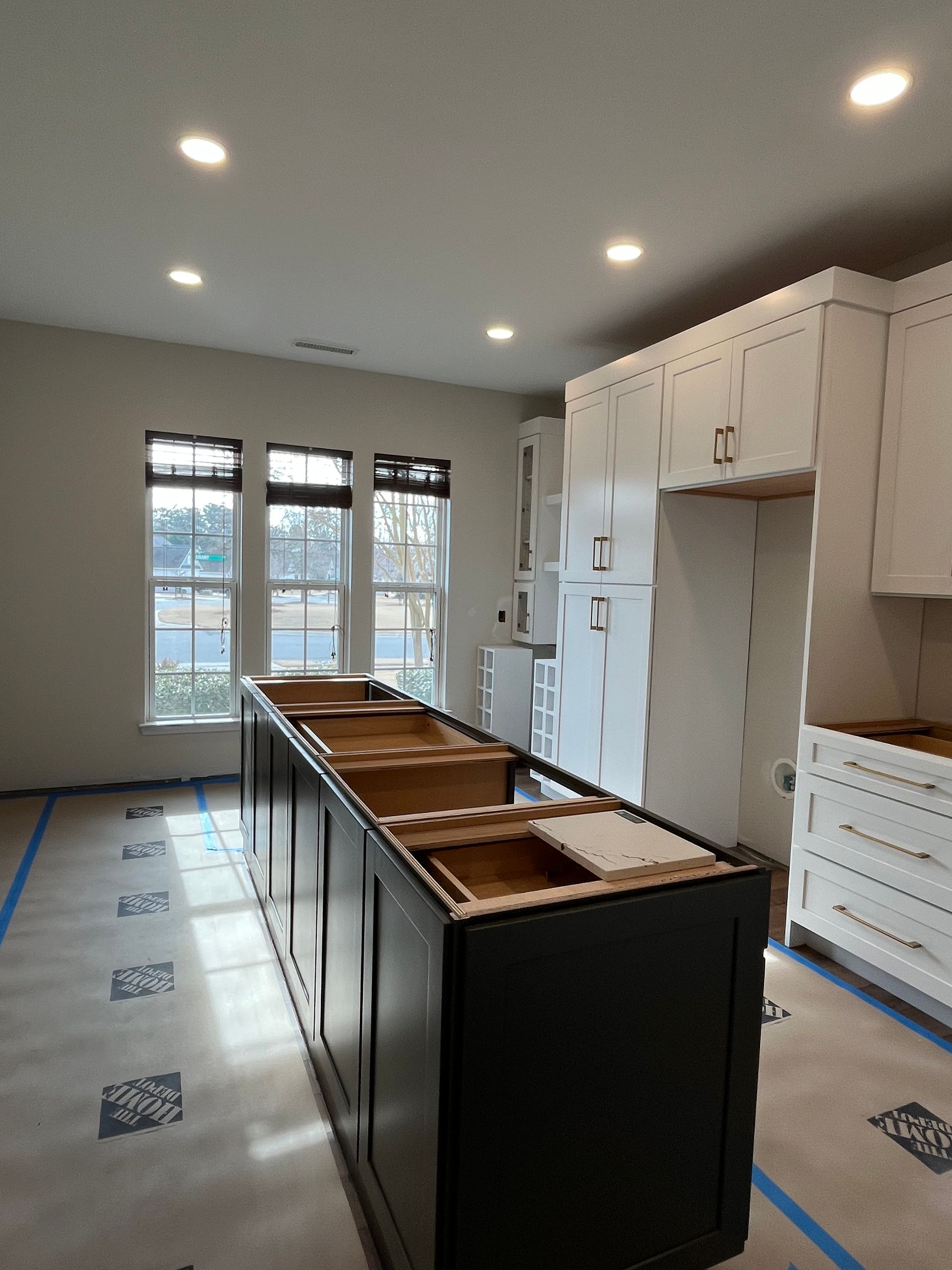 A kitchen is being remodeled with a large island in the middle
