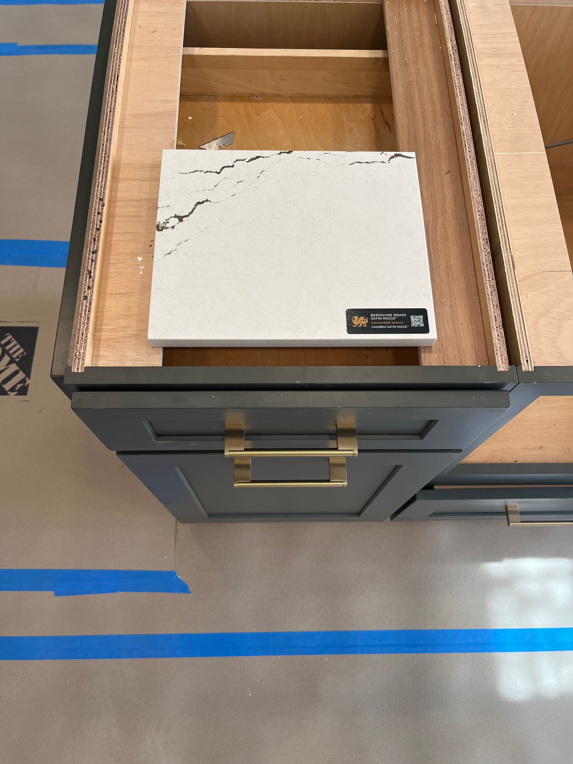 A piece of white tile is sitting on top of a wooden drawer.