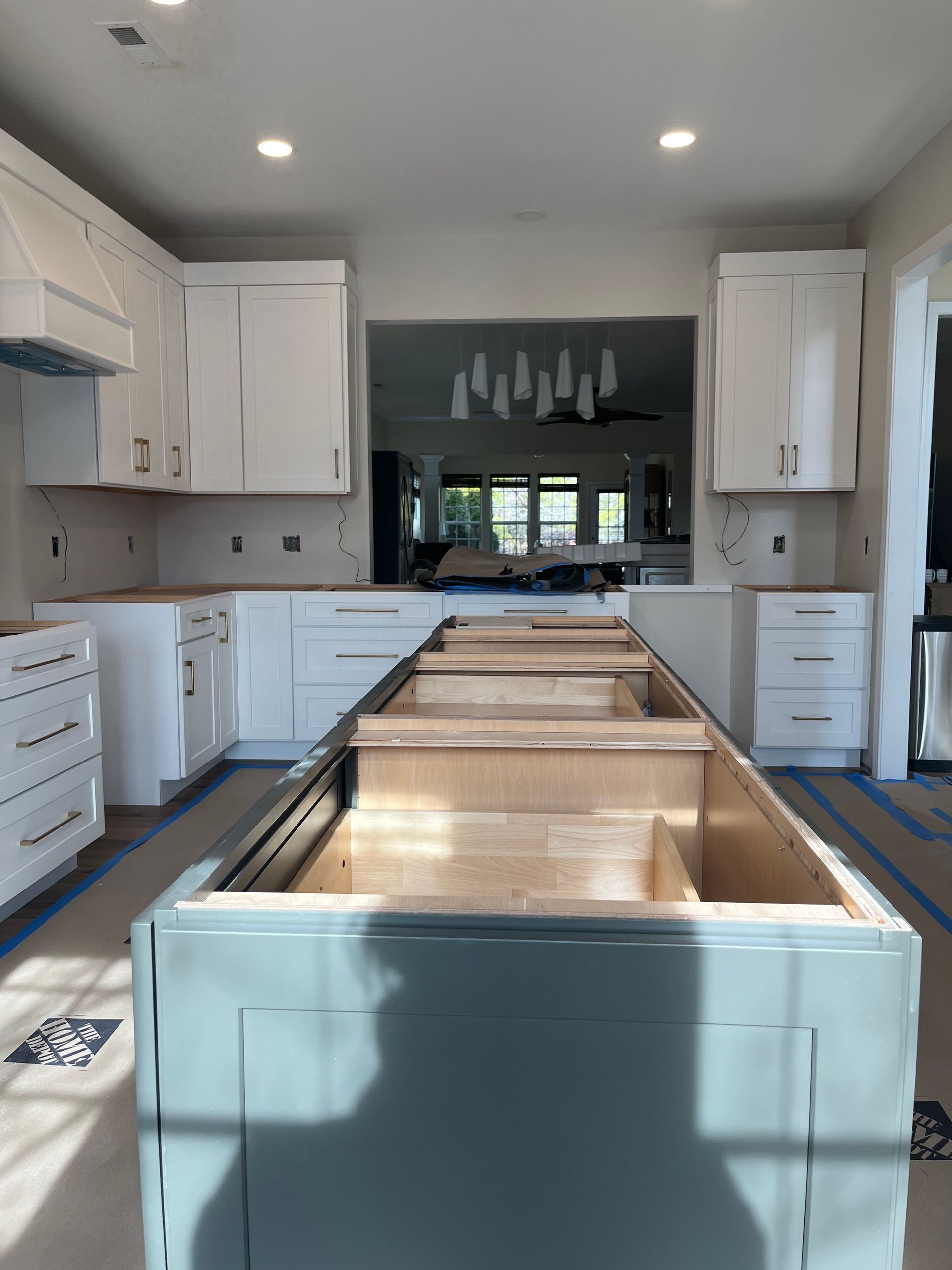 A kitchen under construction with a long island in the middle.