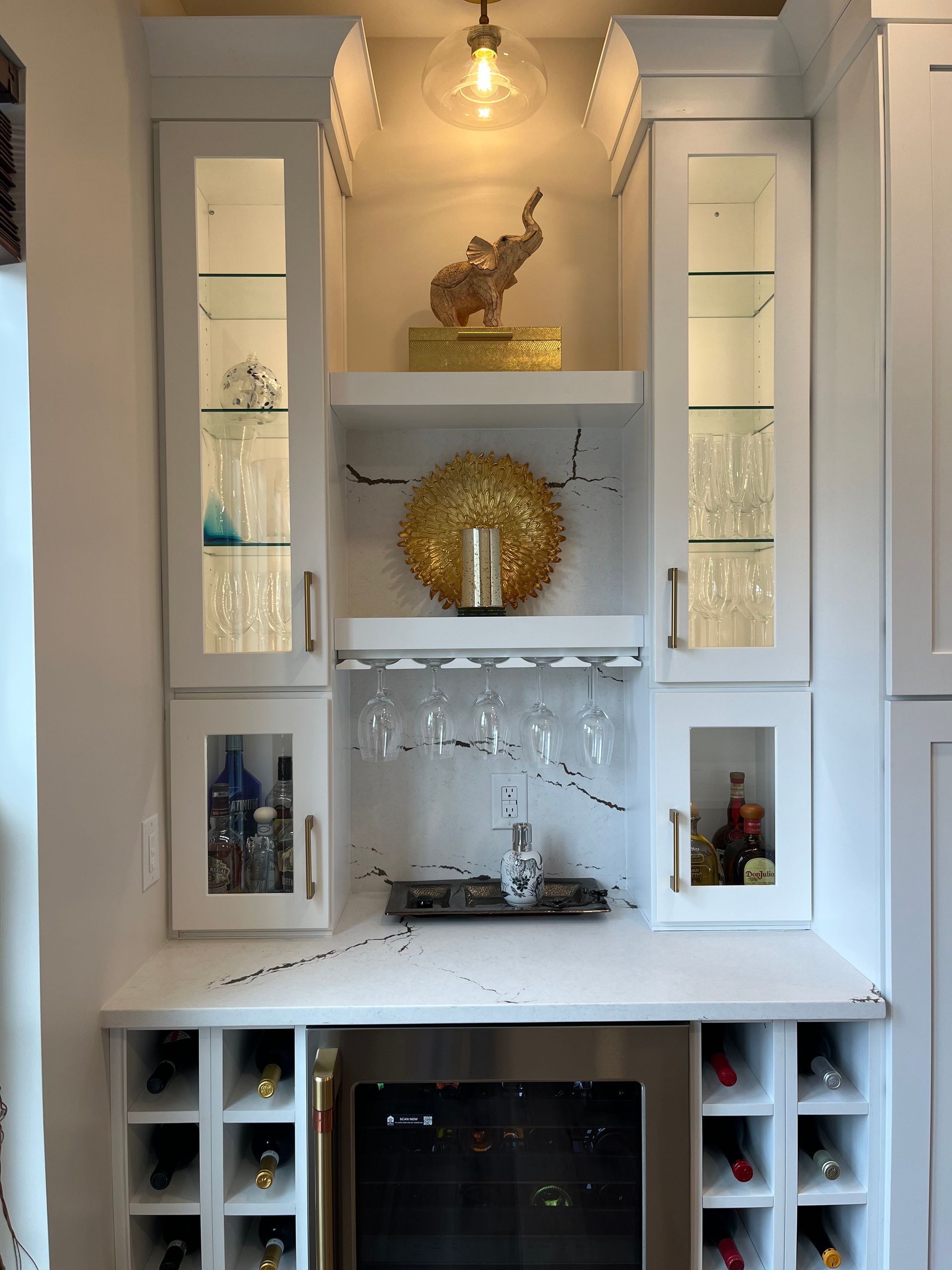 A kitchen with white cabinets and a wine cooler