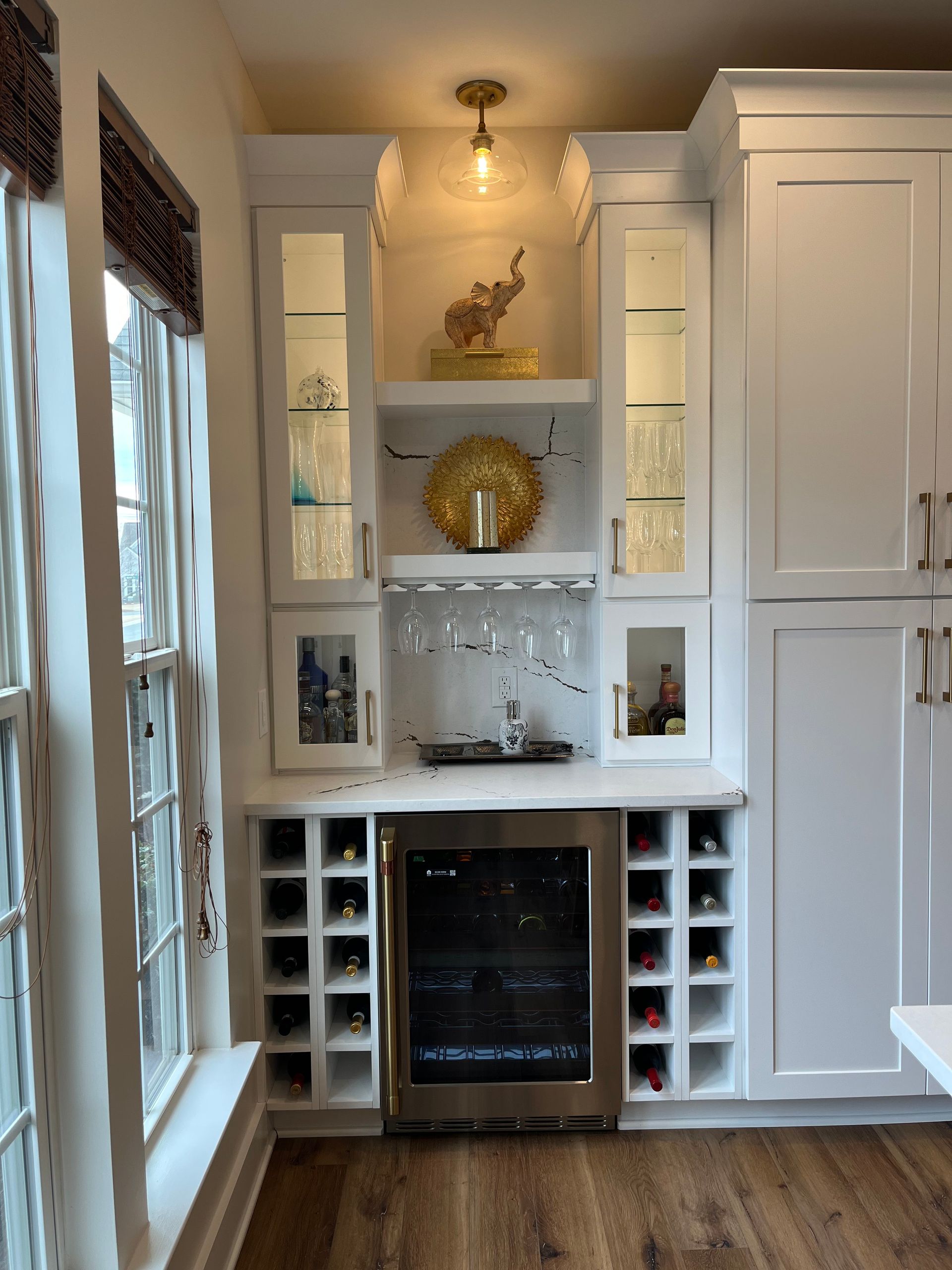 A kitchen with white cabinets and a wine cooler